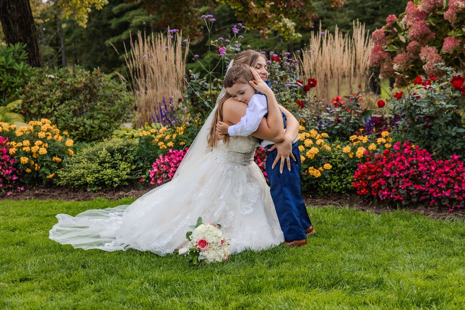 Newlyweds pose together in colorful autumn garden setting.
