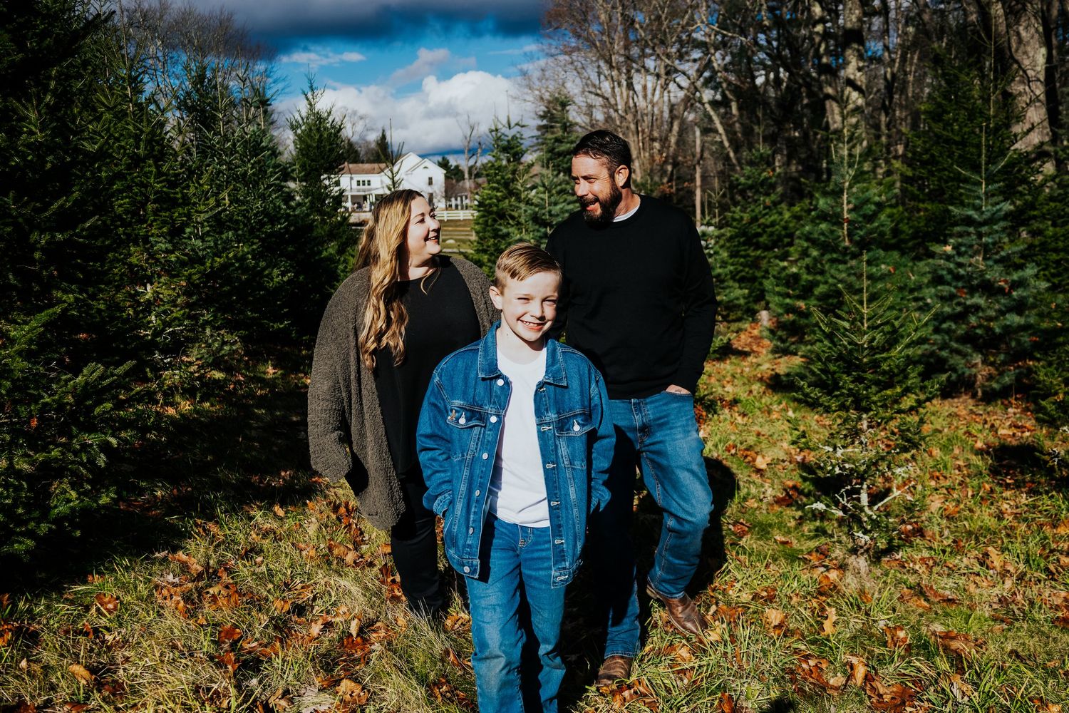 Candid moments captured during an autumn outdoor photoshoot with evergreen trees.