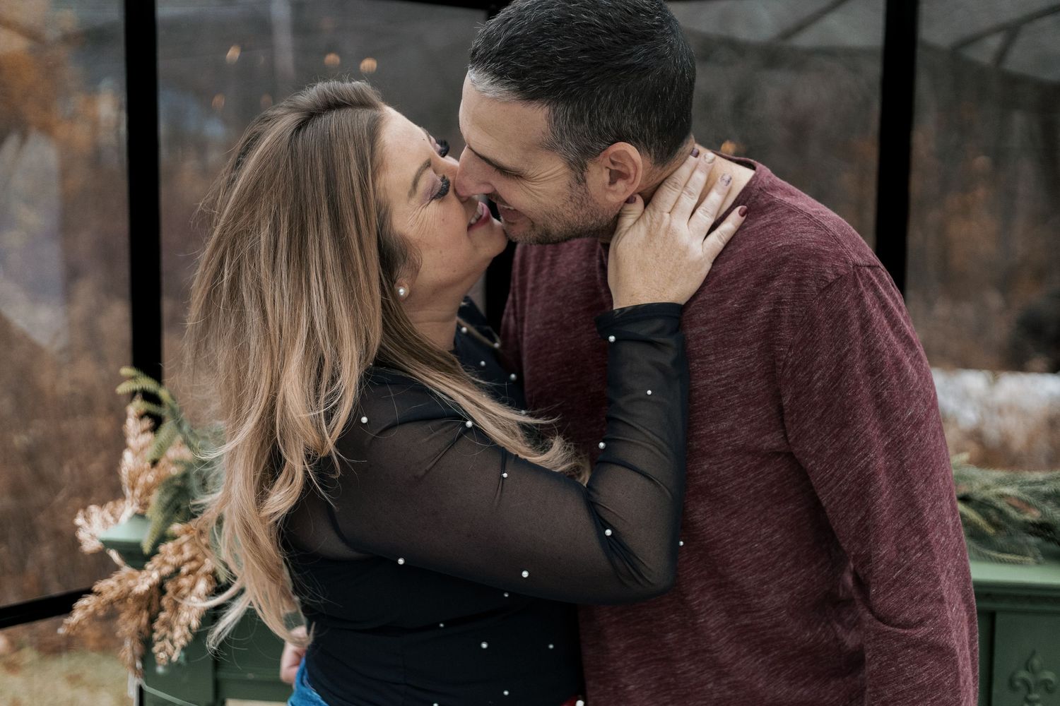 A couple embraces during a romantic winter photo session outdoors.