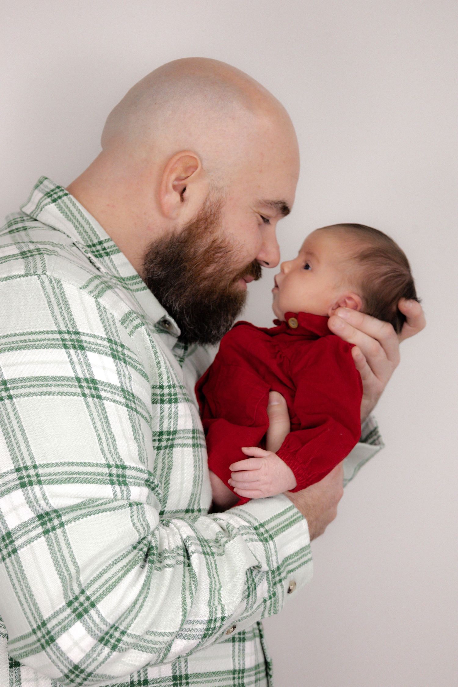 A tender family moment captured against a clean white studio background.
