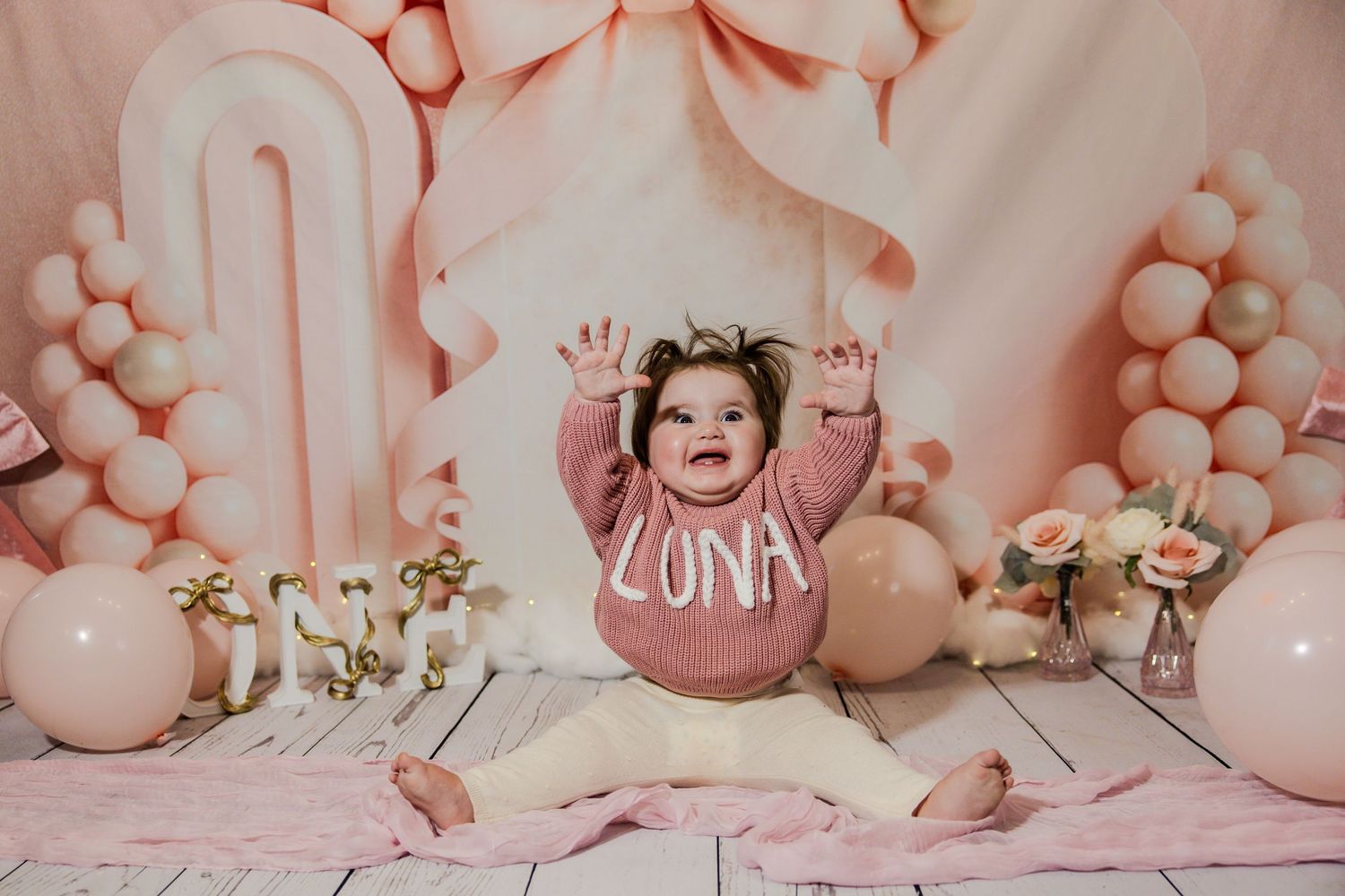 Pink and white balloon decorations create a festive backdrop for a celebration.