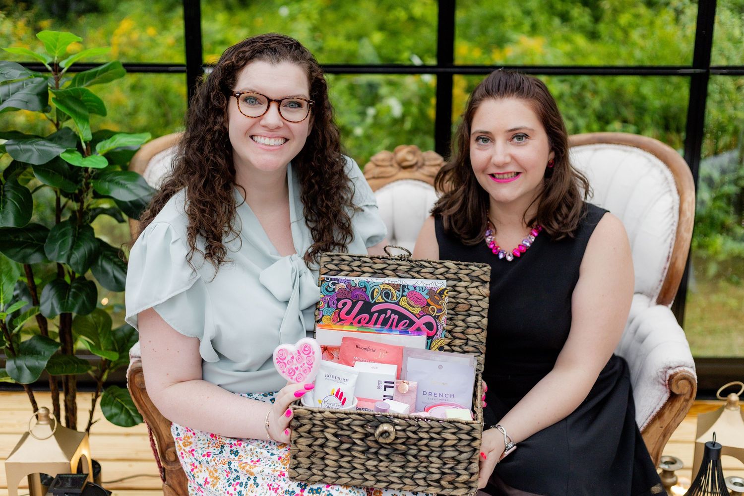People seated on an elegant vintage couch outdoors with gift baskets and decorative items.