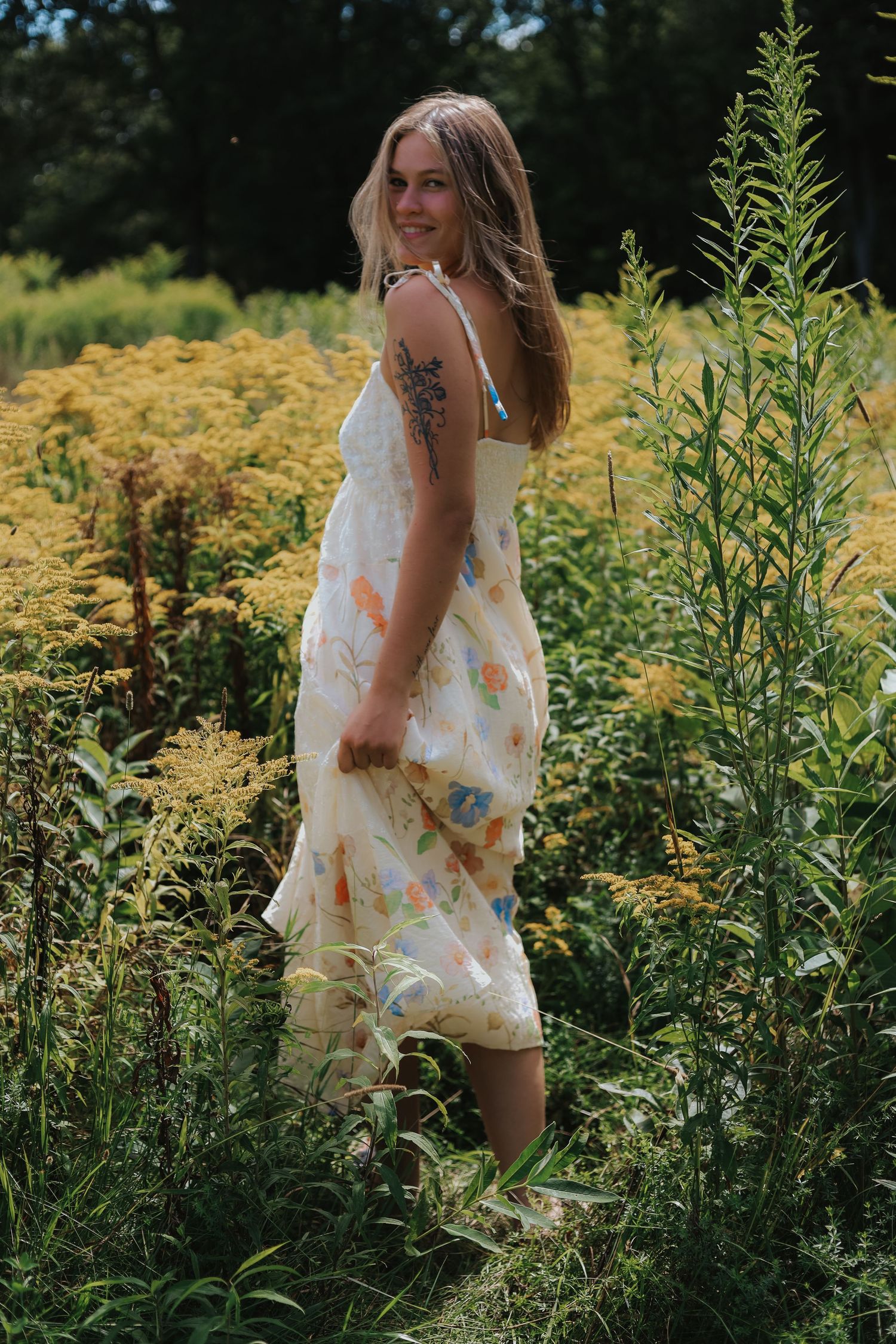 Summer photoshoot in a wildflower field with yellow blooms and tall grass.