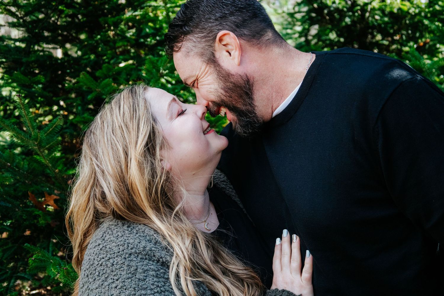 Romantic outdoor photoshoot among lush green foliage and natural lighting.