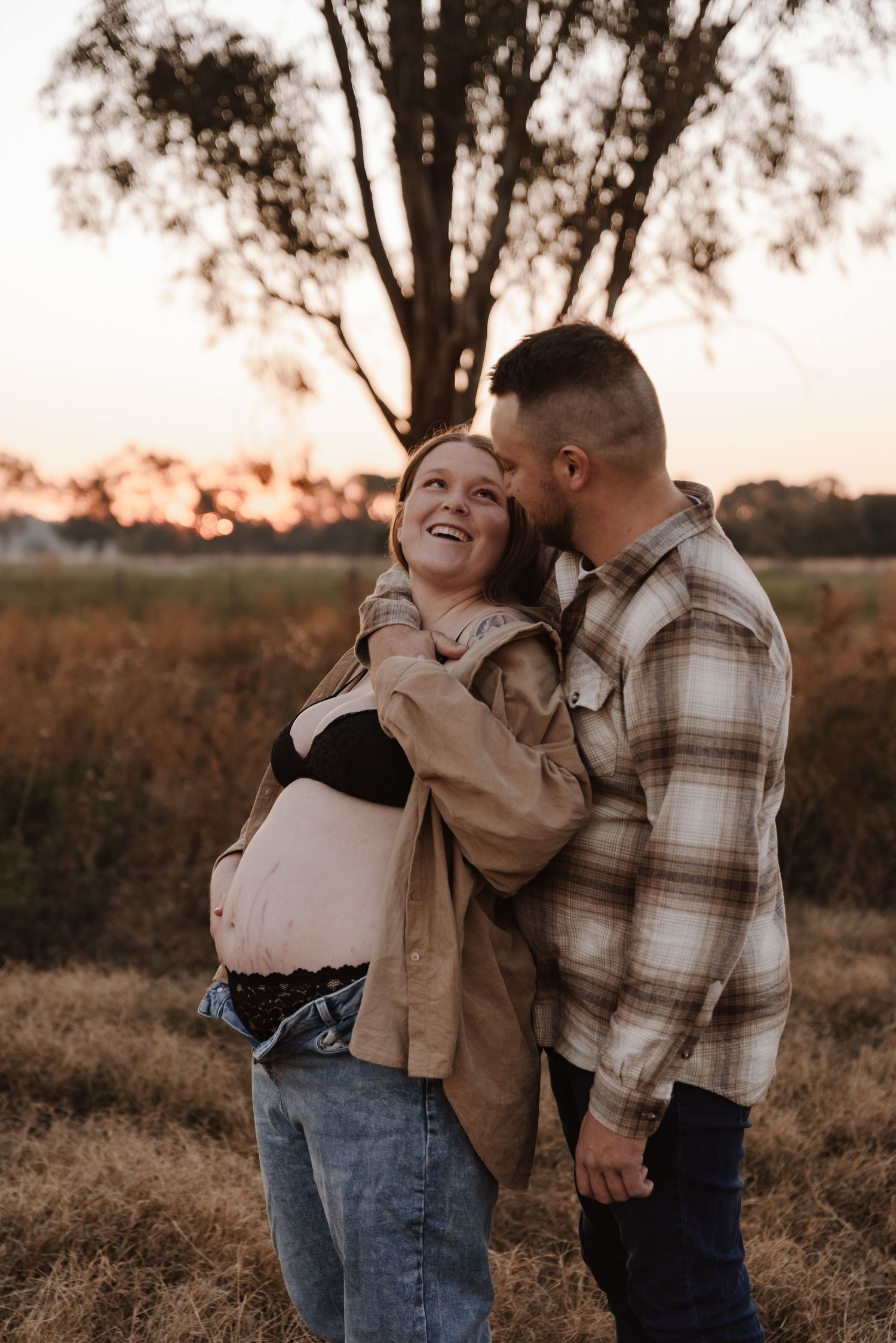 pregnant-mother-with-partner-standing-in-sunset-field-tongala