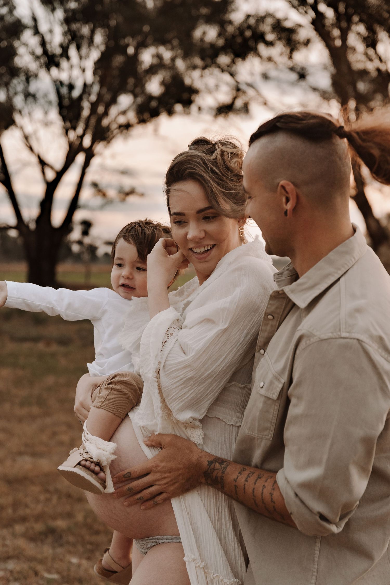 pregnant-mother-with-family-standing-in-sunset-field-tongala