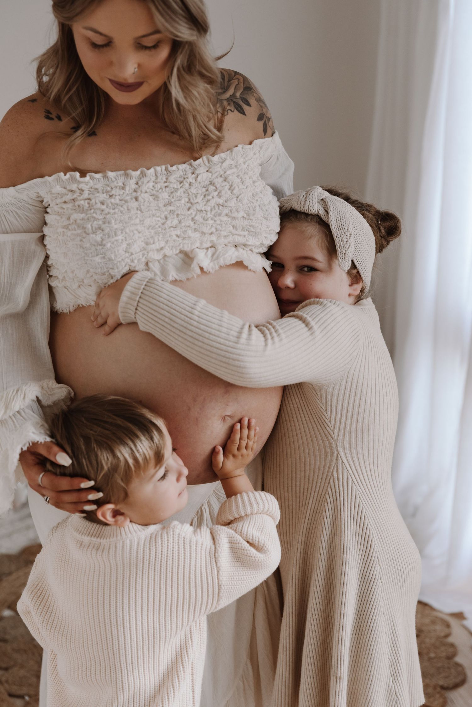 pregnant-mother-with-kids-standing-in-studio-space-tongala