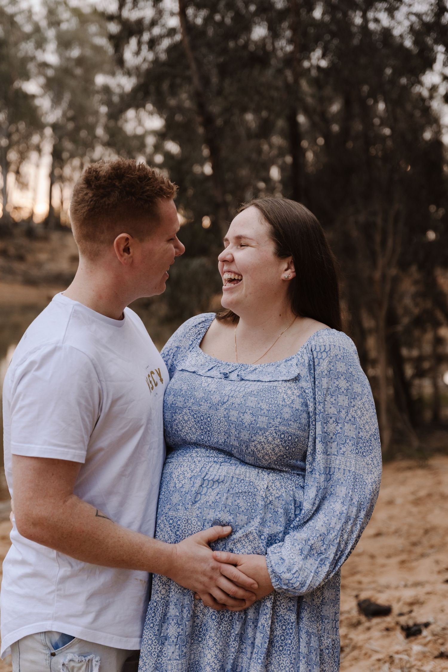 pregnant-mother-with-husband-standing-in-sunset-river-echuca