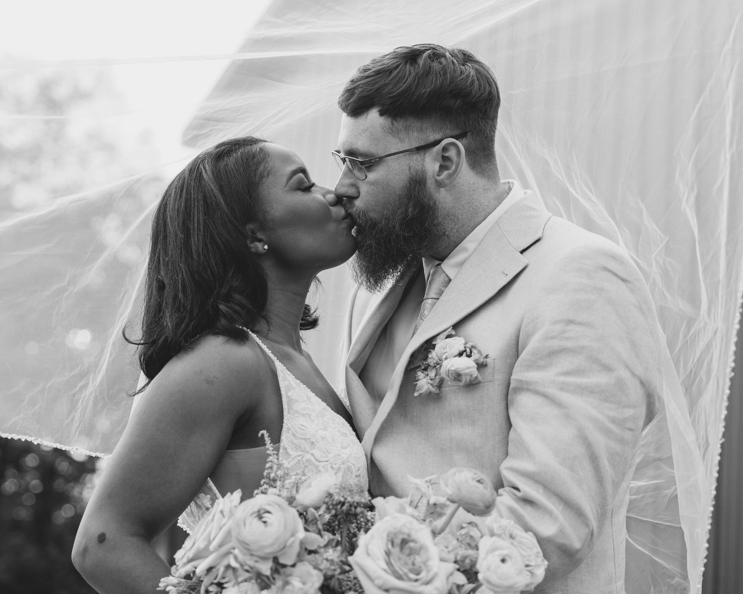Black and white wedding portraits capture tender moments between newlyweds.