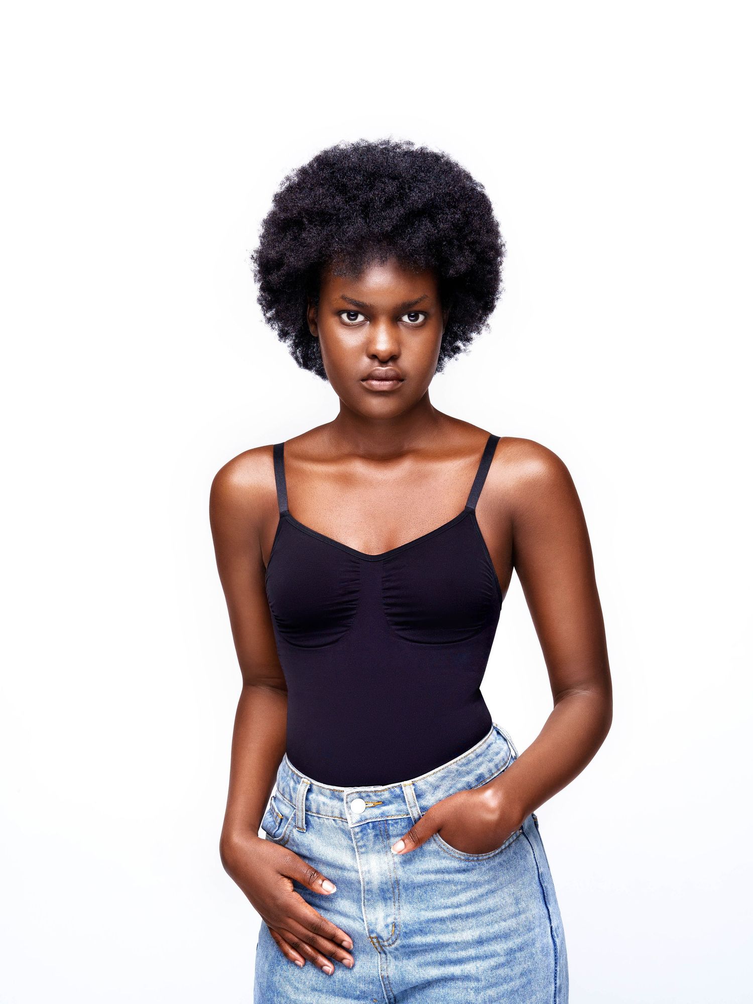 Model in black tank top and vintage denim strikes various poses against white backdrop.