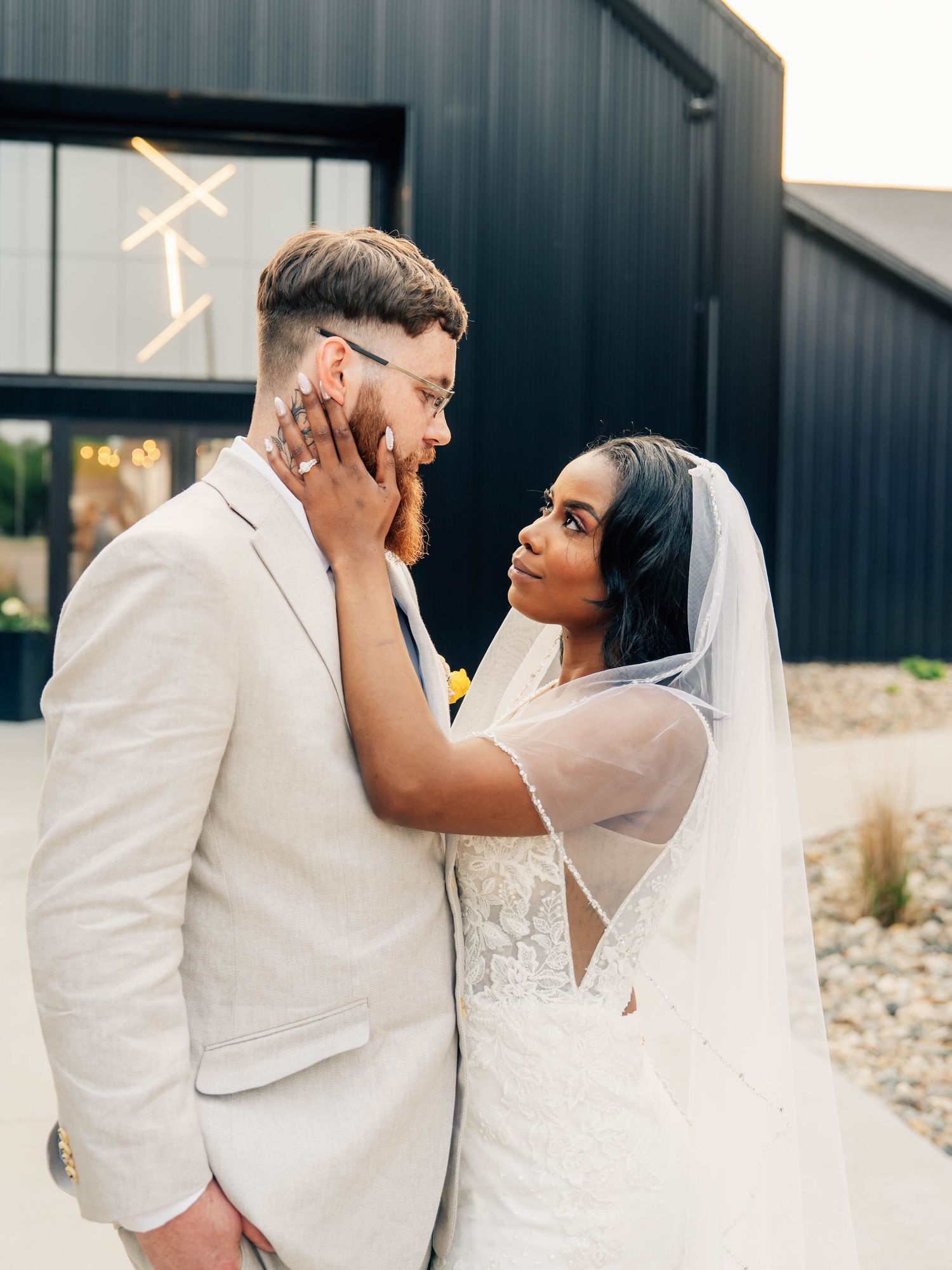 Intimate wedding couple moments captured against dark modern architecture.