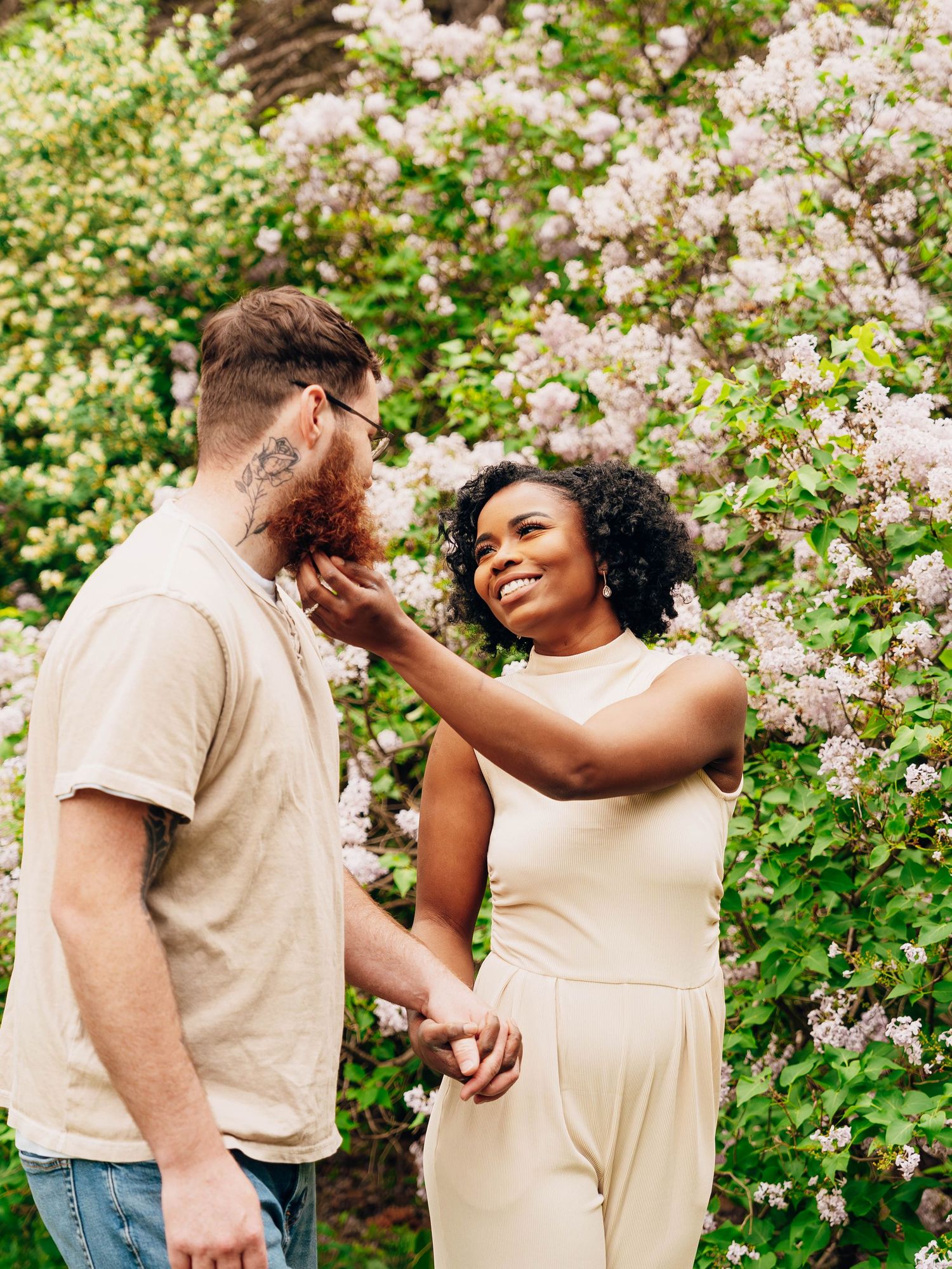 Romantic outdoor portrait among blooming spring flowers in natural garden setting.