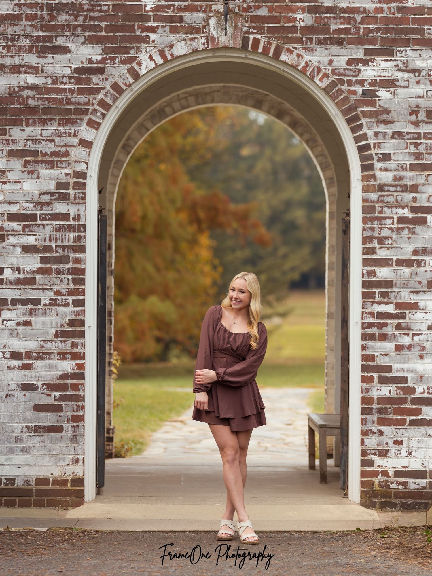A series of five portrait photos taken under a rustic brick archway during autumn with golden foliage in the background.