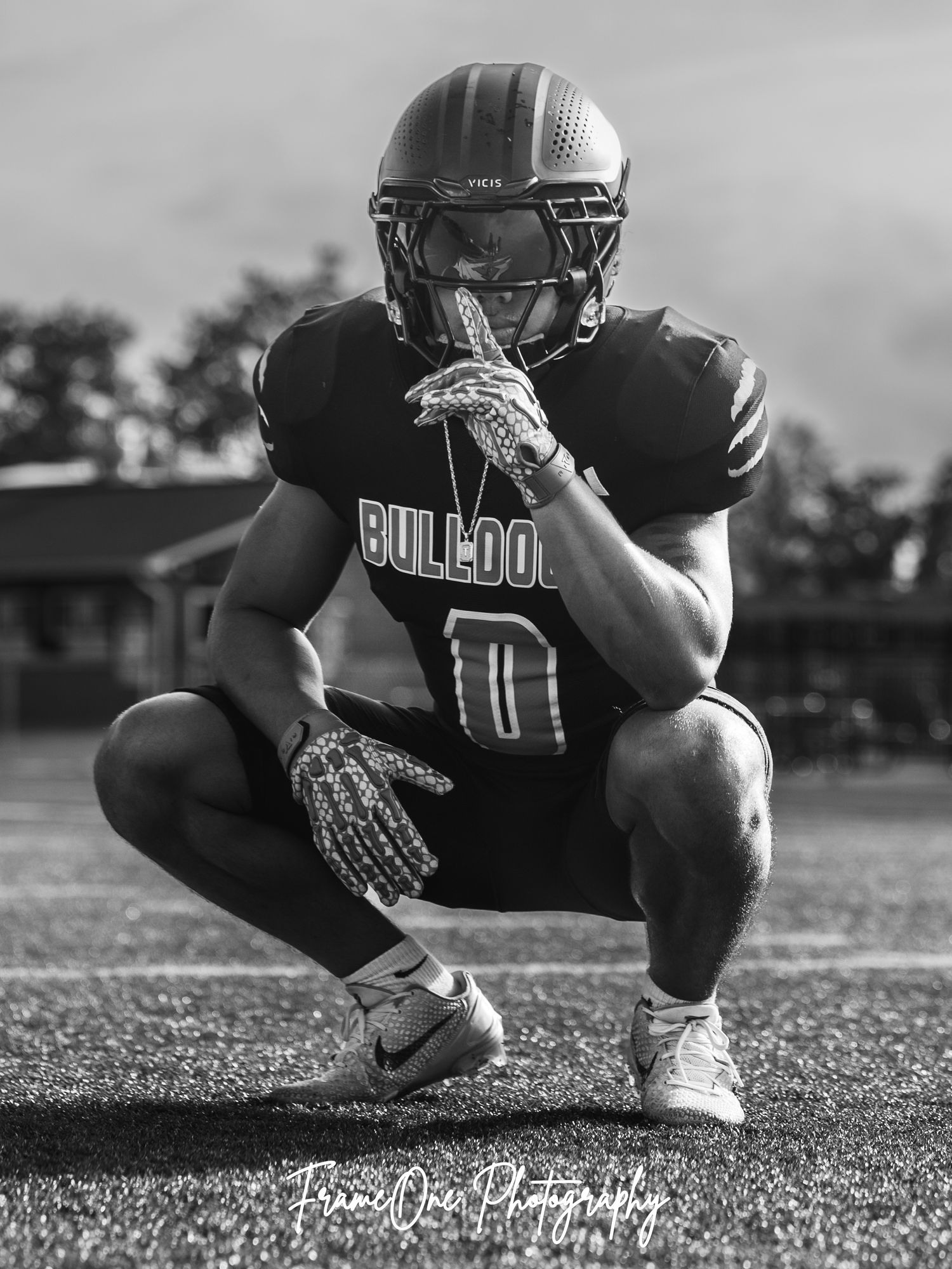 Black and white photo series showing football player crouching in ready position on field during practice.