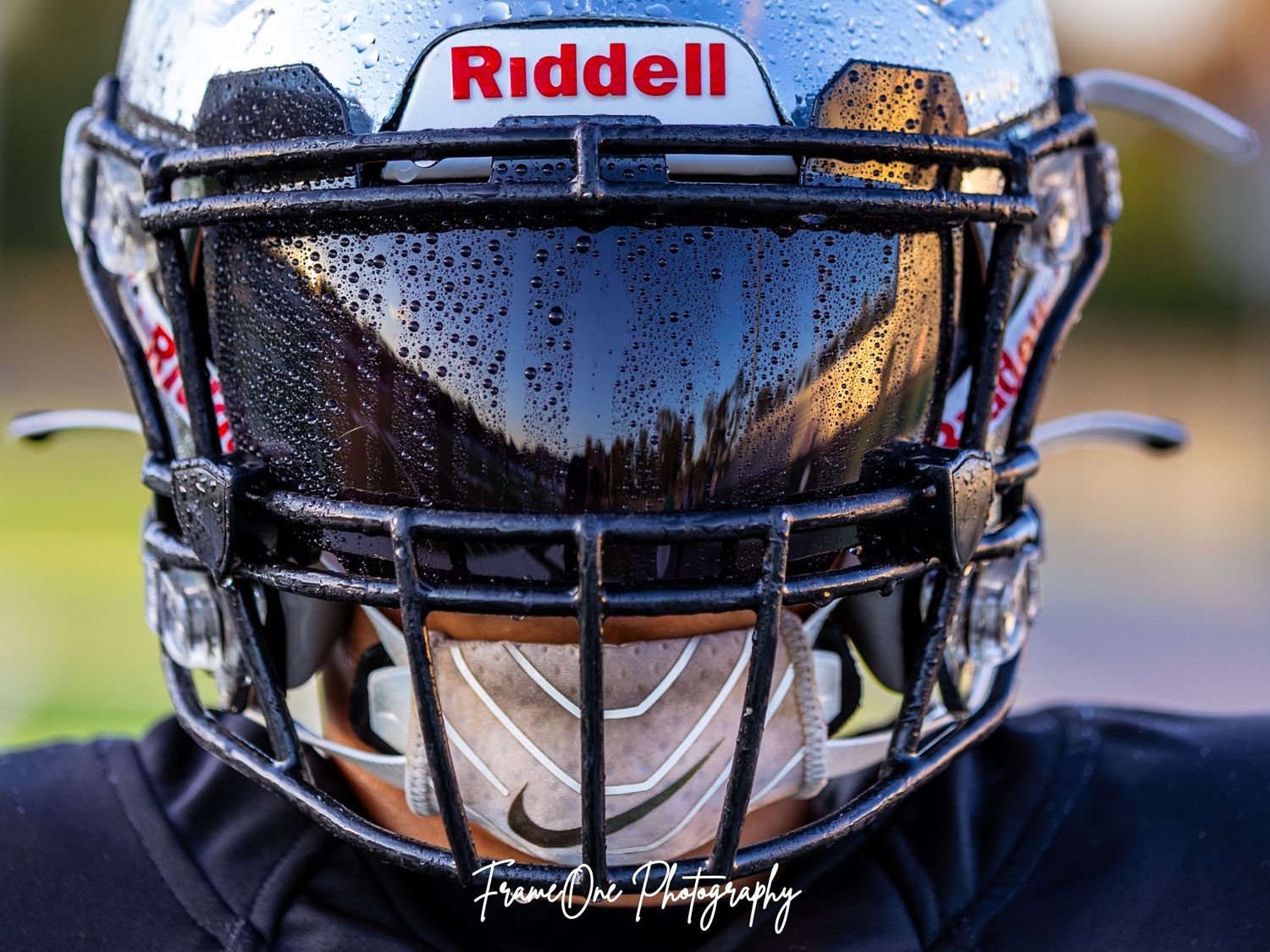 Close-up shots of football helmets with Riddell branding show water droplets on their glossy surfaces during a game.