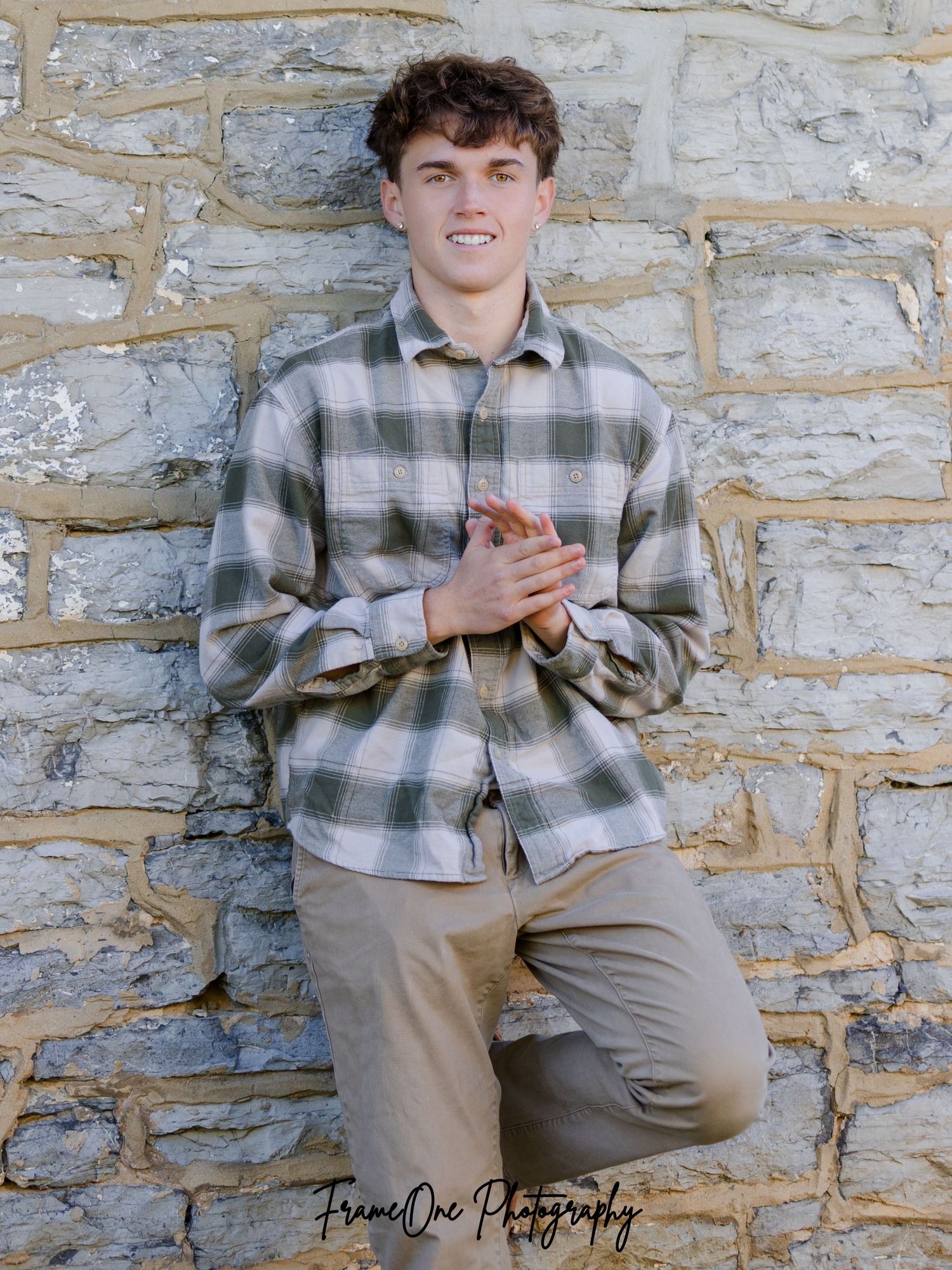 A series of four casual portrait photos against a rustic stone wall showing someone in a plaid flannel shirt and khaki pants.