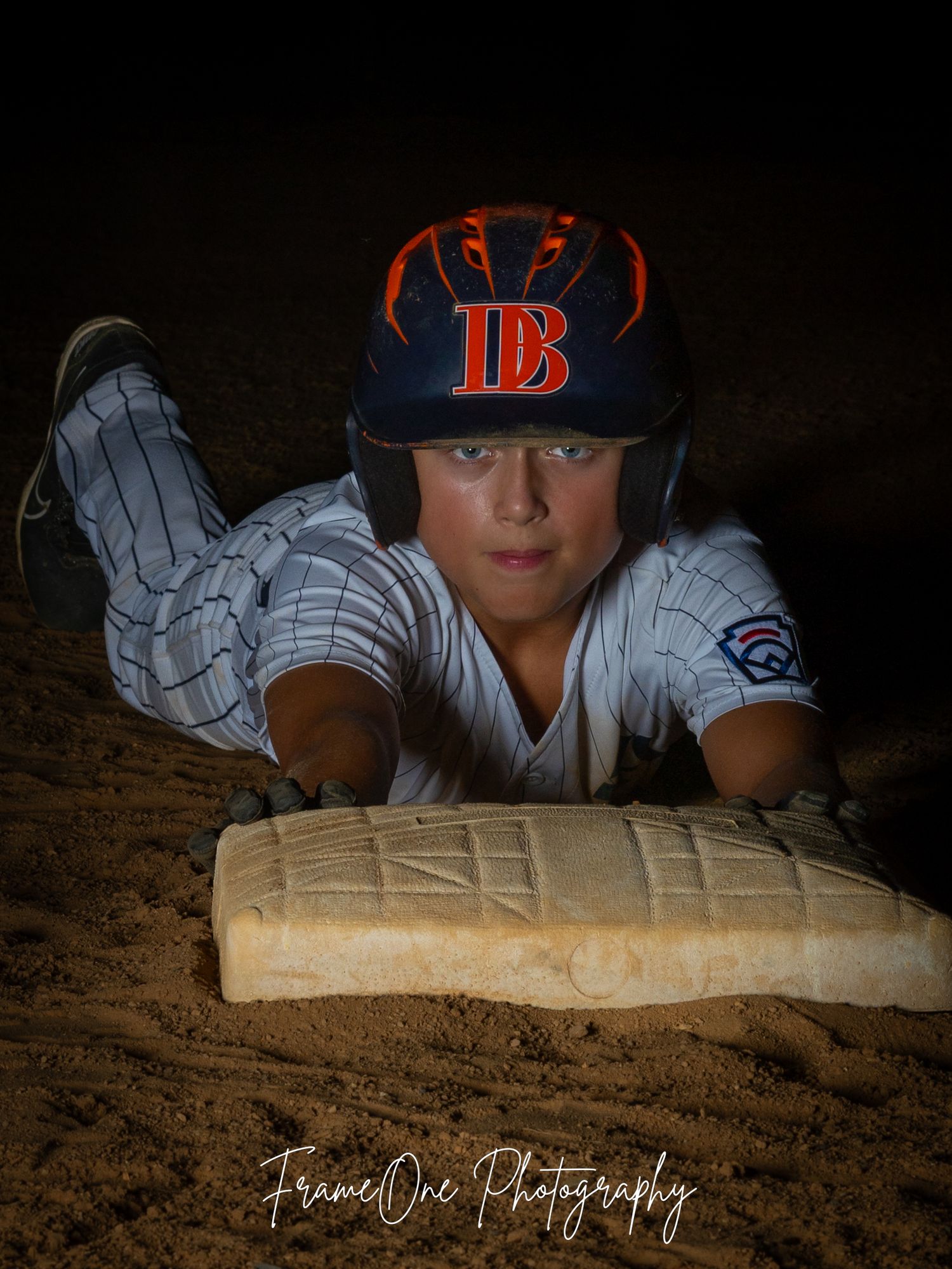 Baseball player wearing a Tampa Bay Rays uniform holds a wooden baseball bat in a dramatic low-light setting.