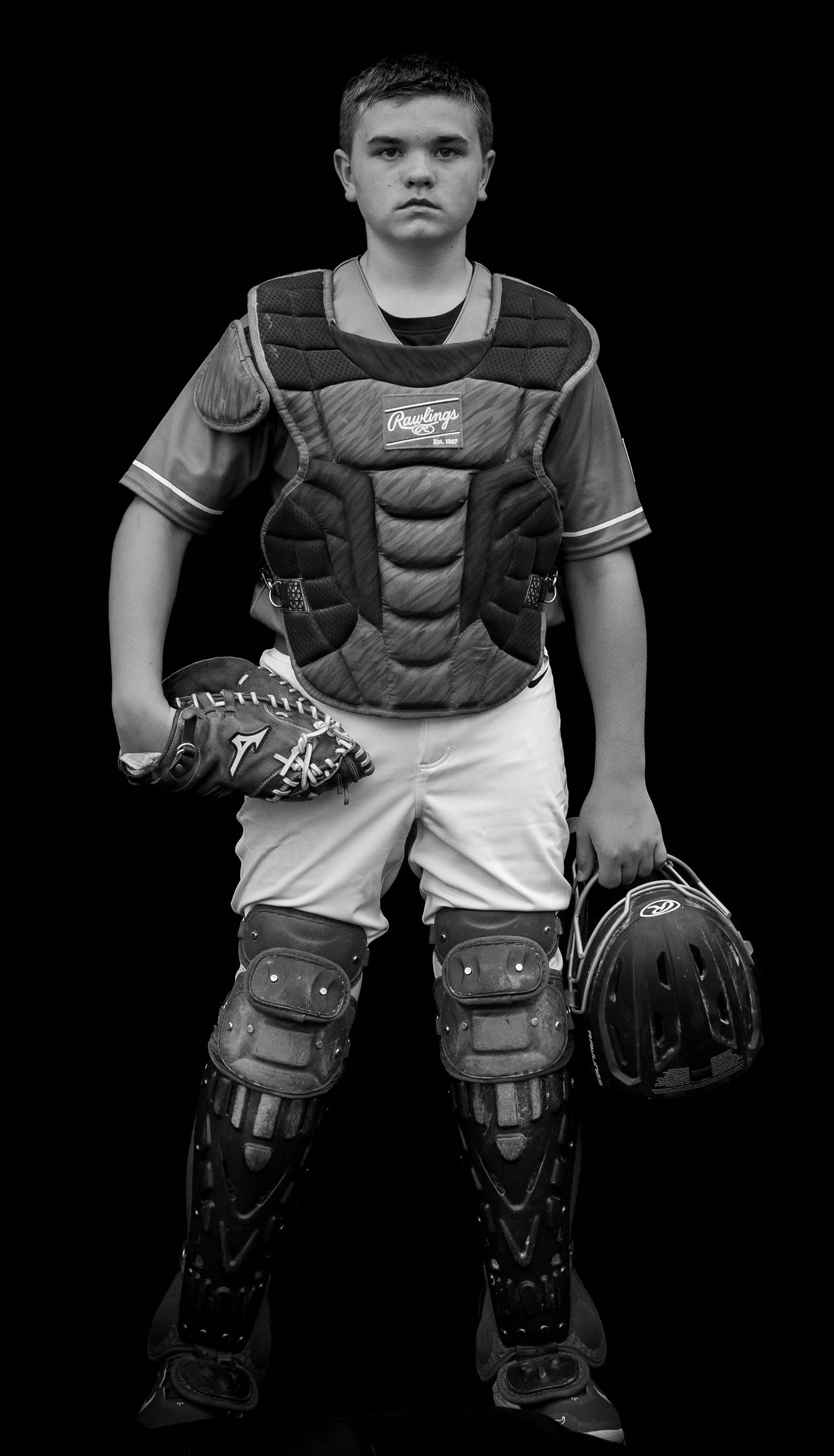 Baseball catcher gear and protective equipment displayed on black background.