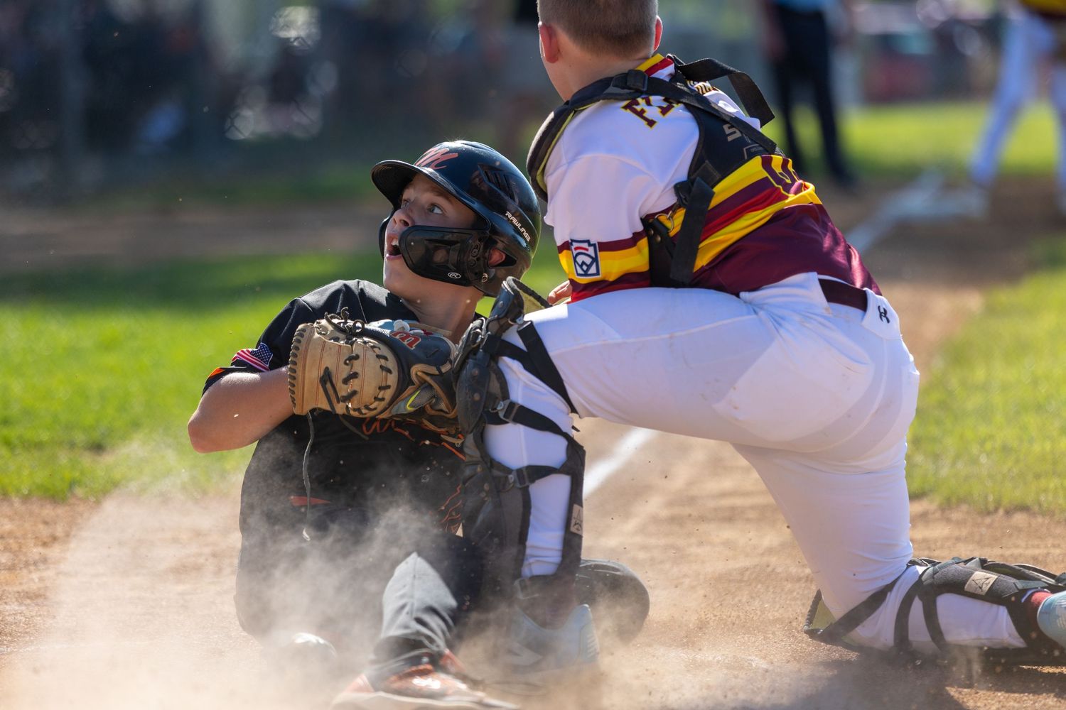 Dramatic action shot of baseball players colliding at home plate.