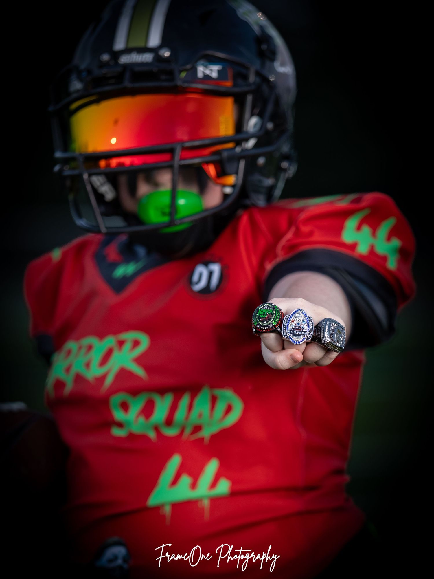 Sequence of close-up shots showing motorcycle rider in red jersey with green accents and glossy black helmet.