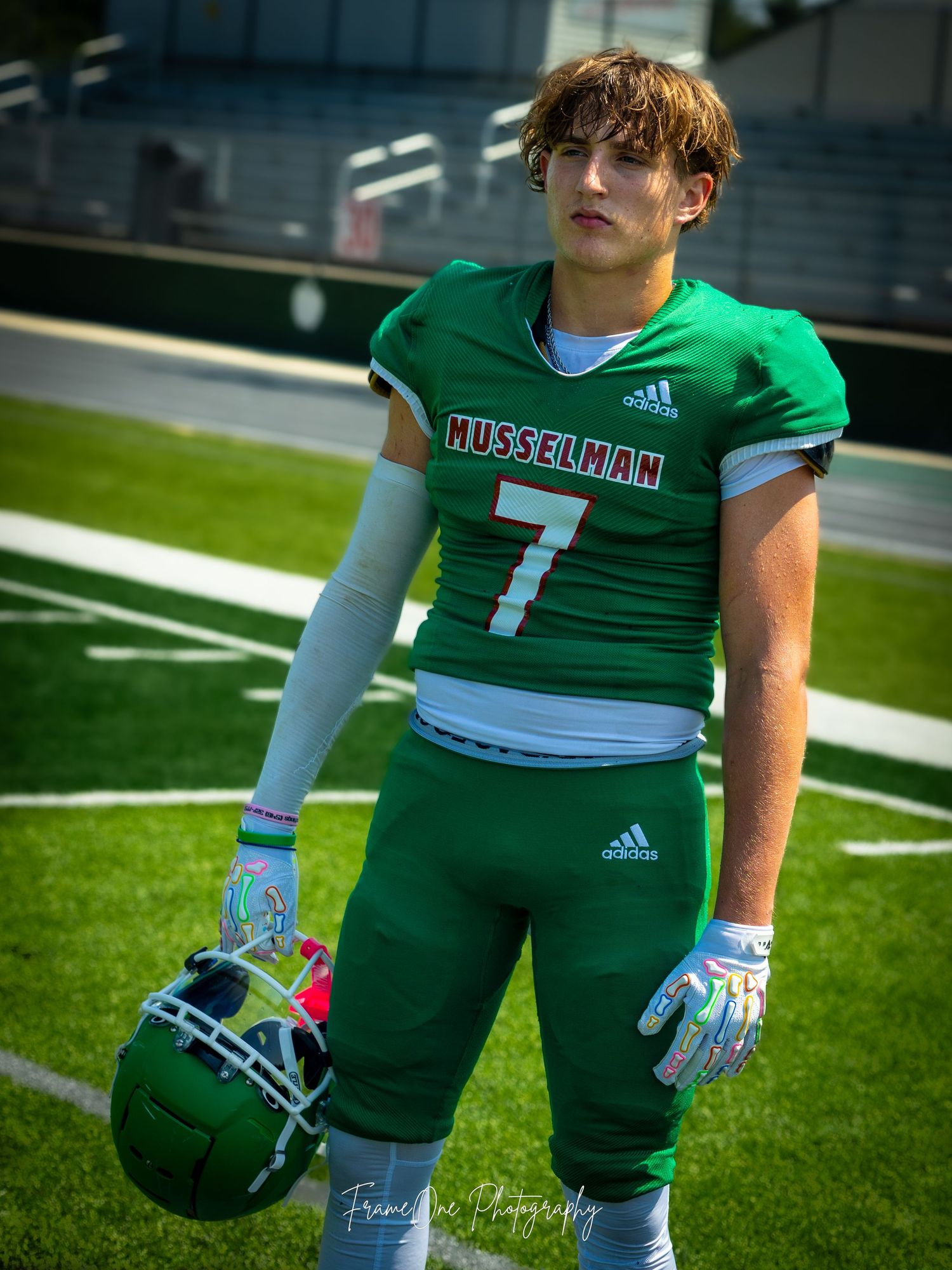 Football player wearing a green Missouri Western number 7 jersey poses for photo on athletic field.