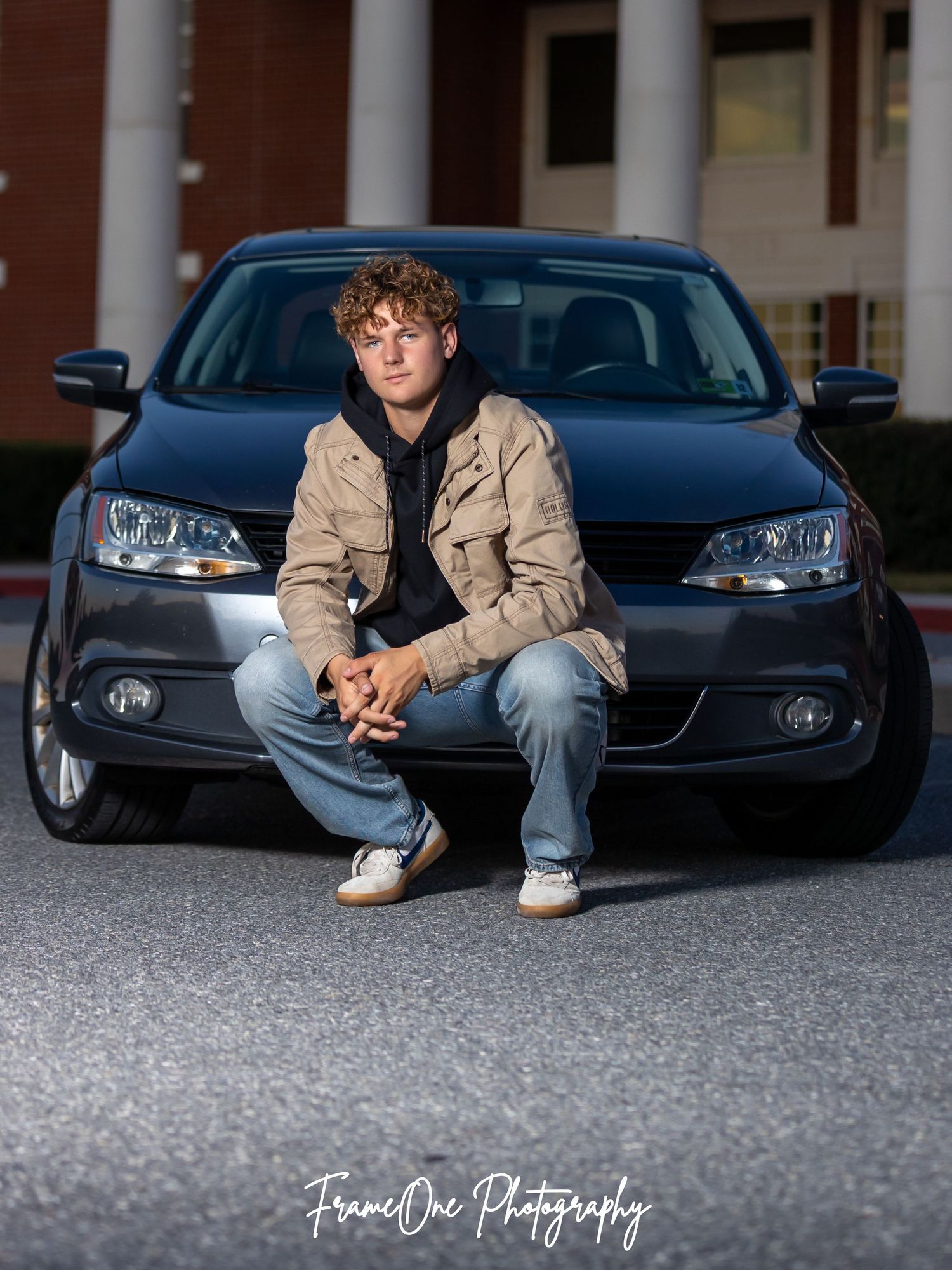 A series of senior portrait photos showing casual poses against a parked blue car in a street setting.