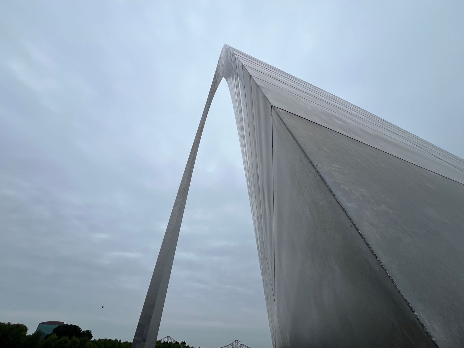 Low angle view of the Gateway Arch monument against cloudy sky in St. Louis.