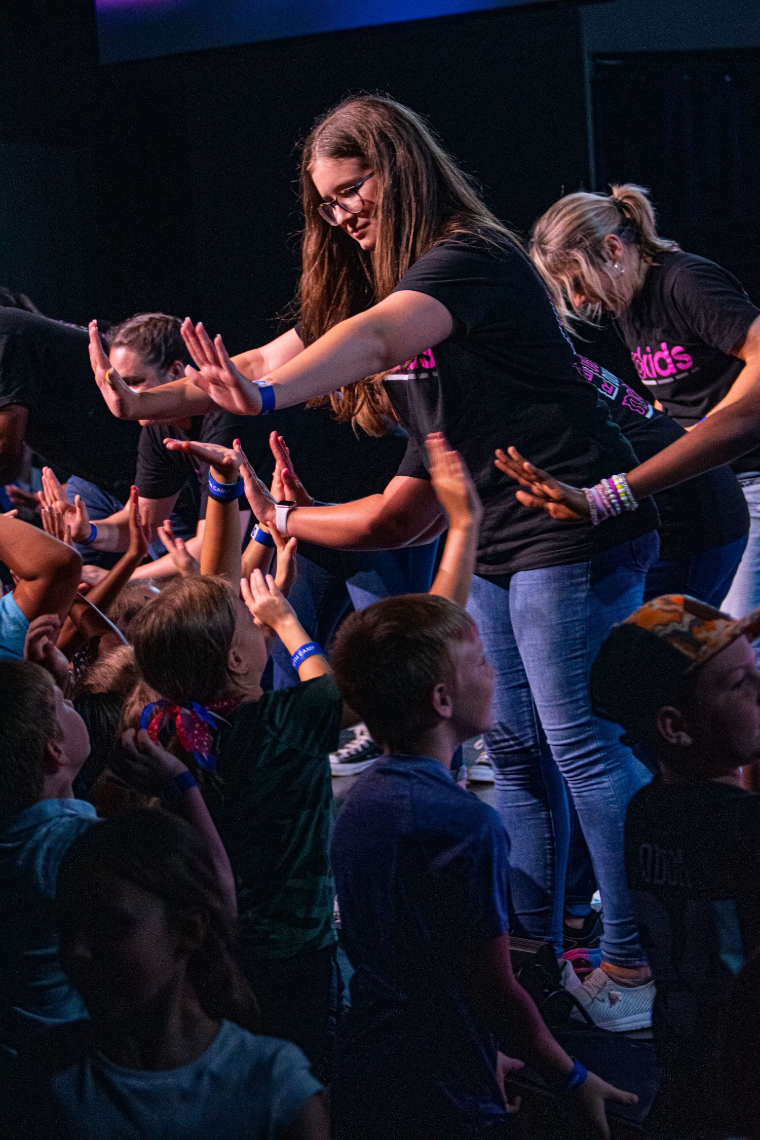 A photo of a woman high-fiving children