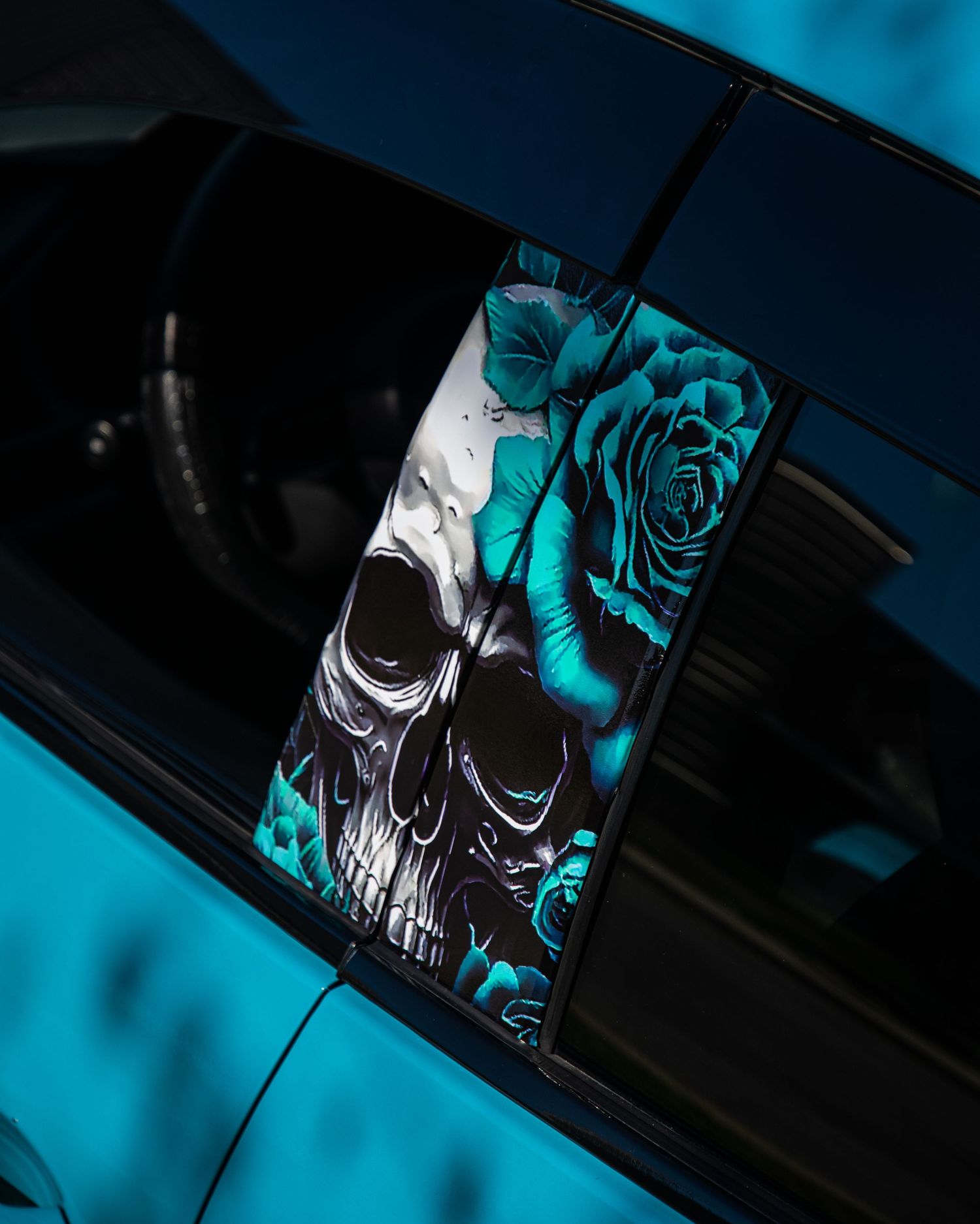 A photo of a sticker of a skill and rose on the side of a car