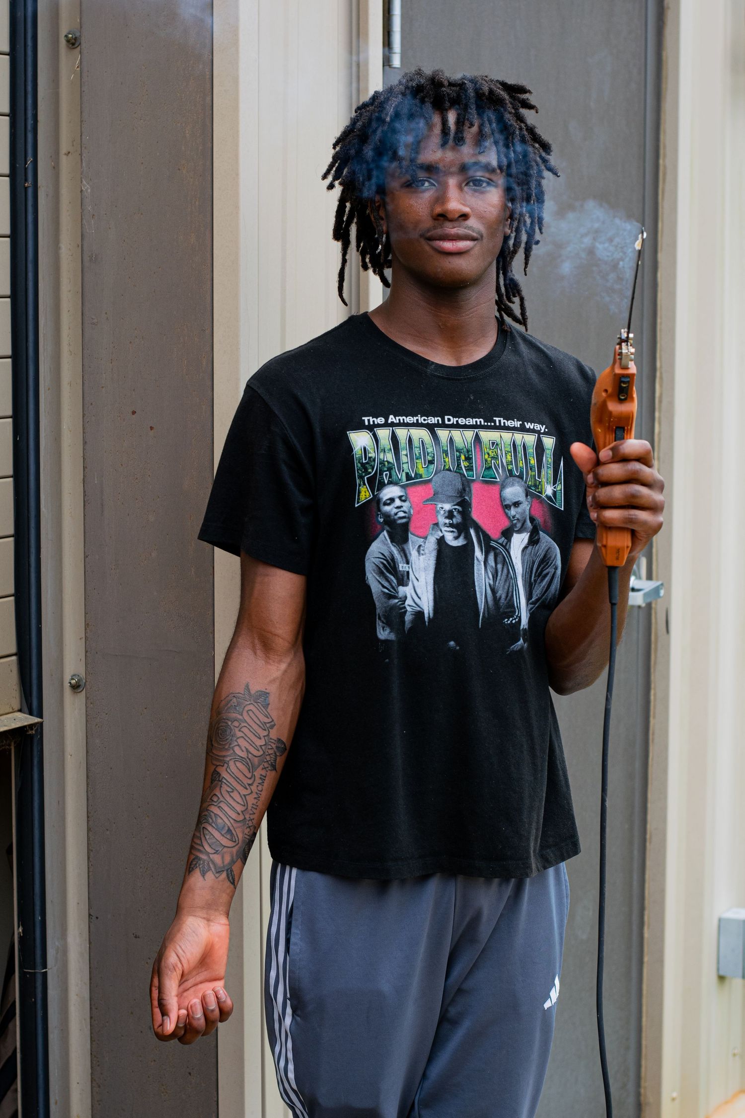 A photo of a man holding a tool and posing