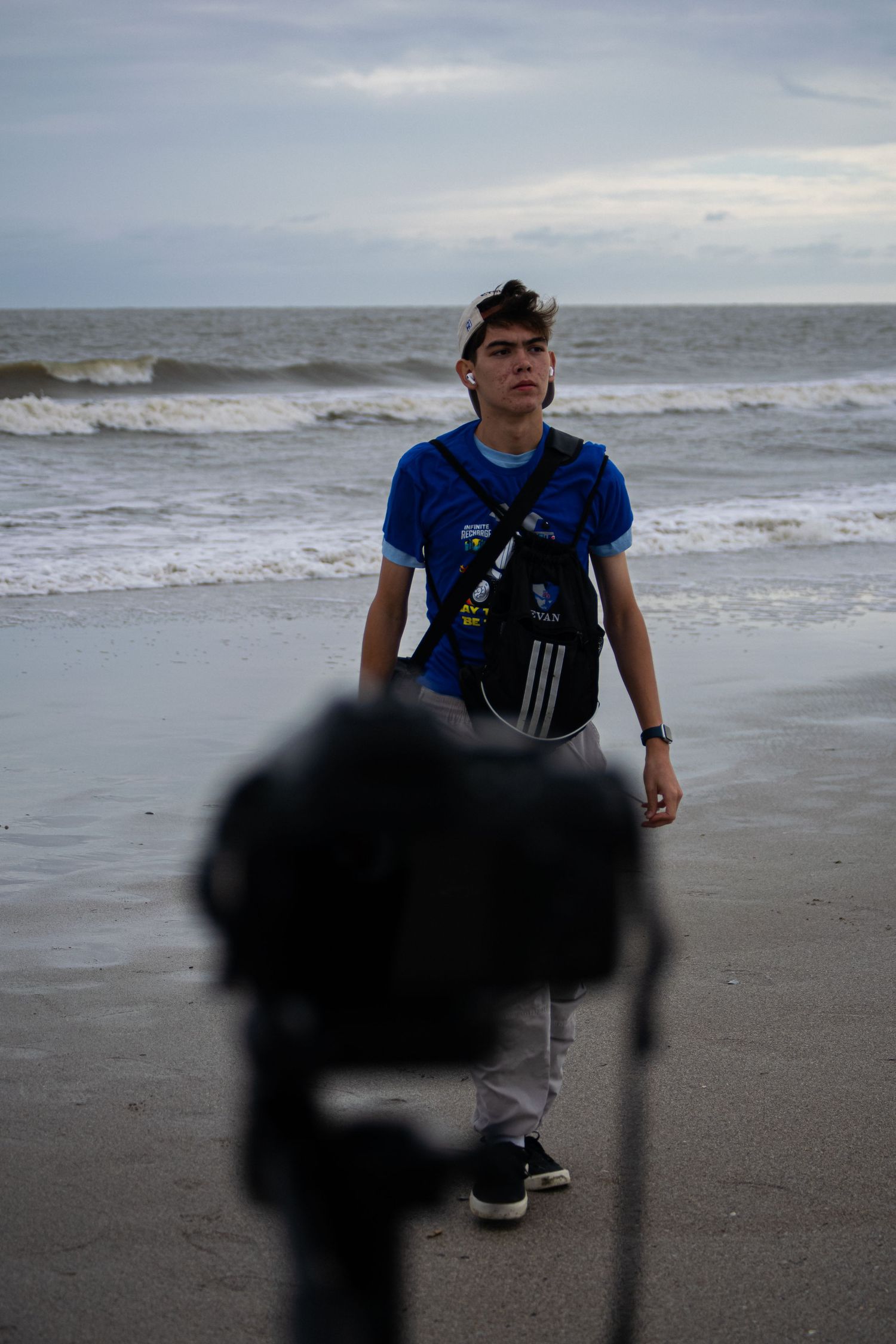 A photographer walking to his camera at a beach