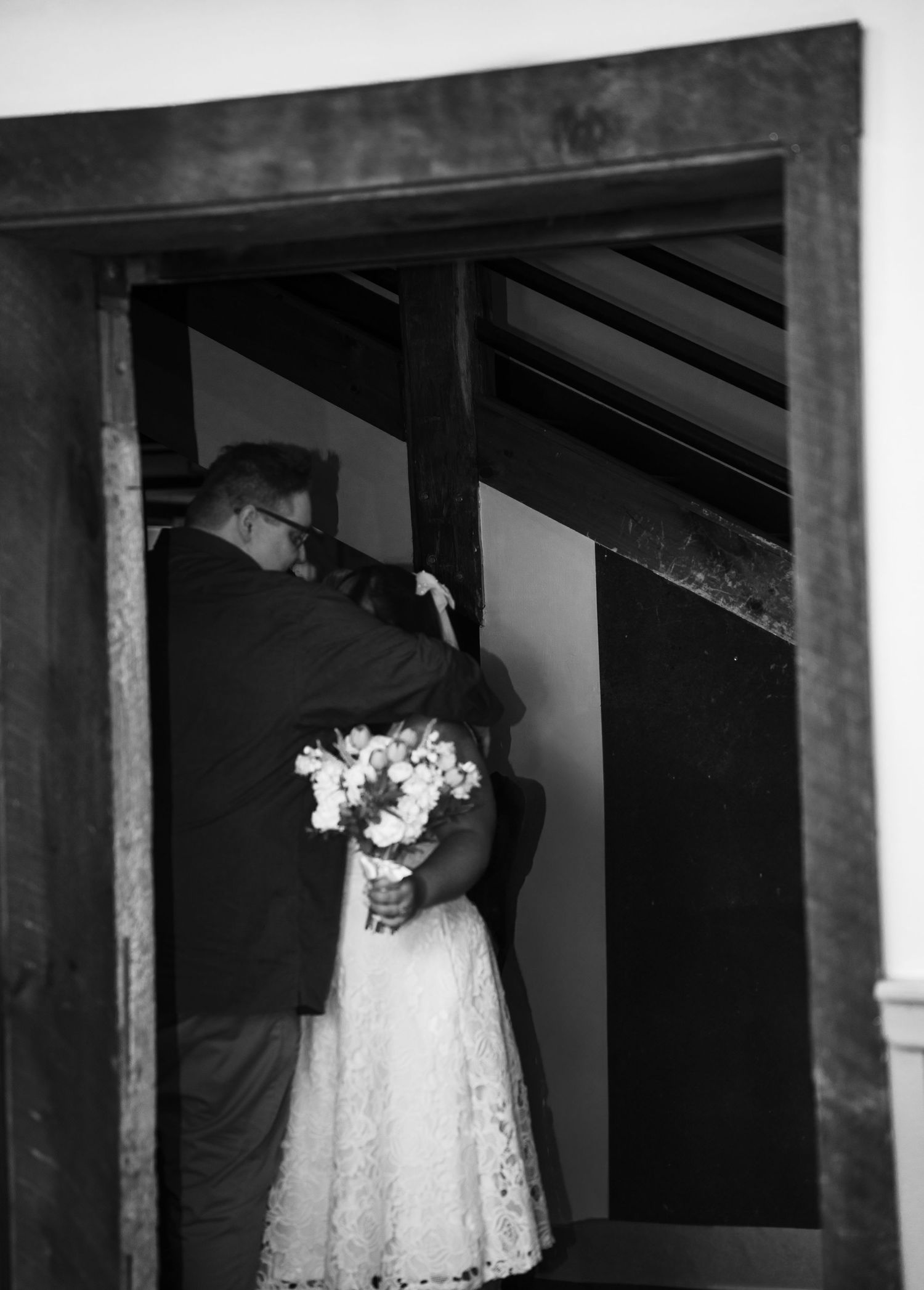A series of black and white photographs showing fragments of a white lace dress at different angles in a shadowed space.