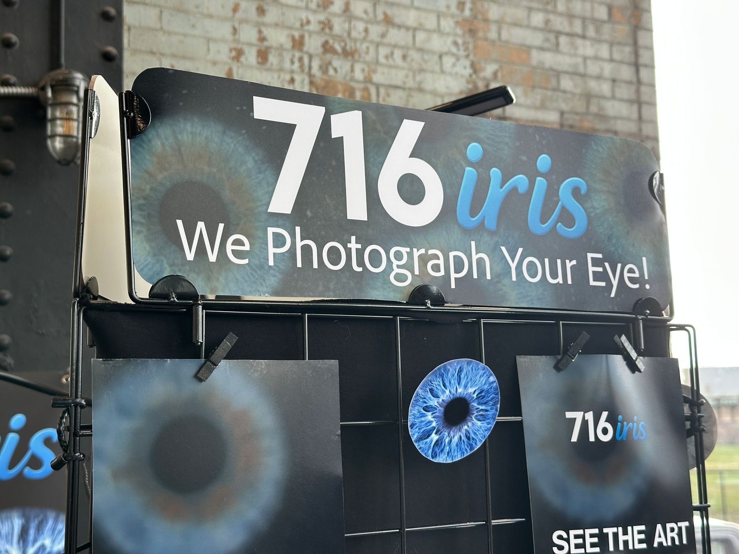 Sign for 716 Iris photography studio advertising professional eye iris photography services displayed outdoors.