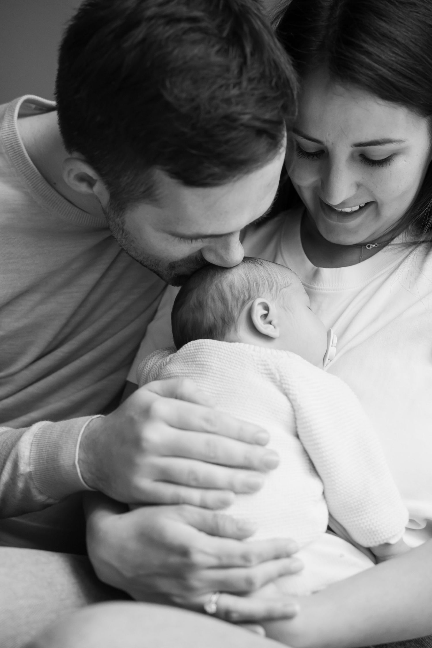 Modernes und zeitloses Newborn Fotoshooting in Berlin mit Eltern und Neugeborenem in einer nahen eleganten Schwarz Weiß Ästhetik in Berlin