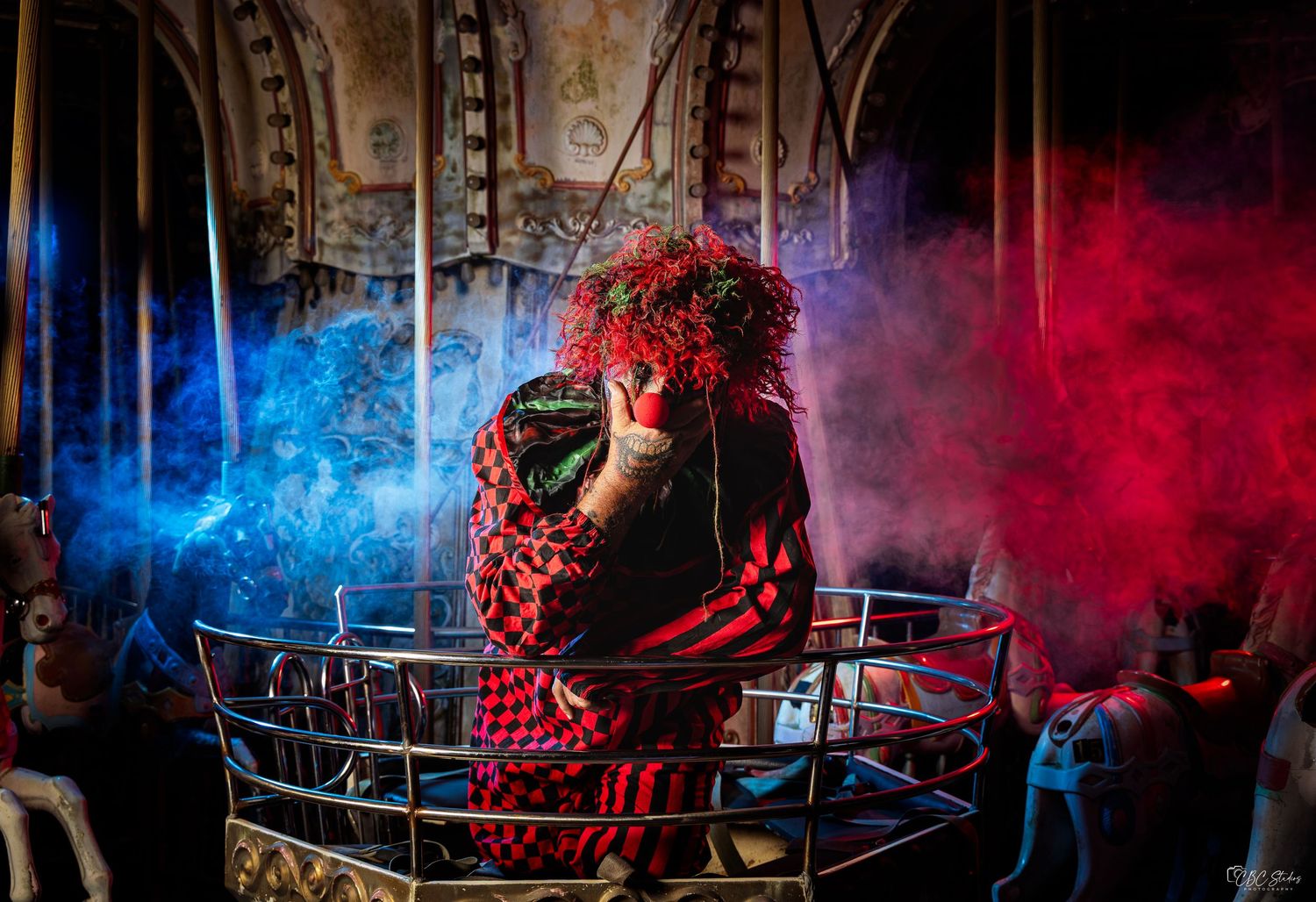 Atmospheric stage performance with dramatic red and blue smoke effects illuminating dark theater scenery.