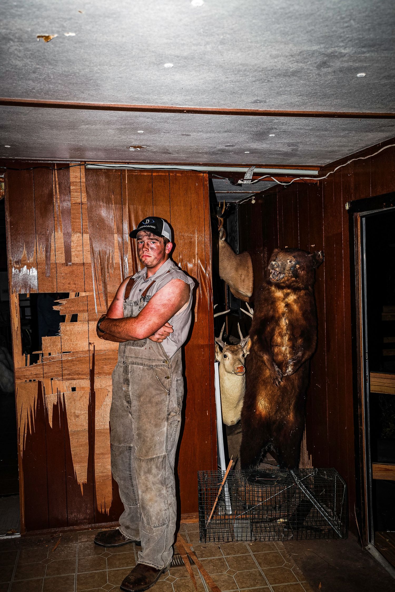 A sequence of photos shows someone in overalls inspecting a dark basement or crawl space with mounted animal heads on the walls.