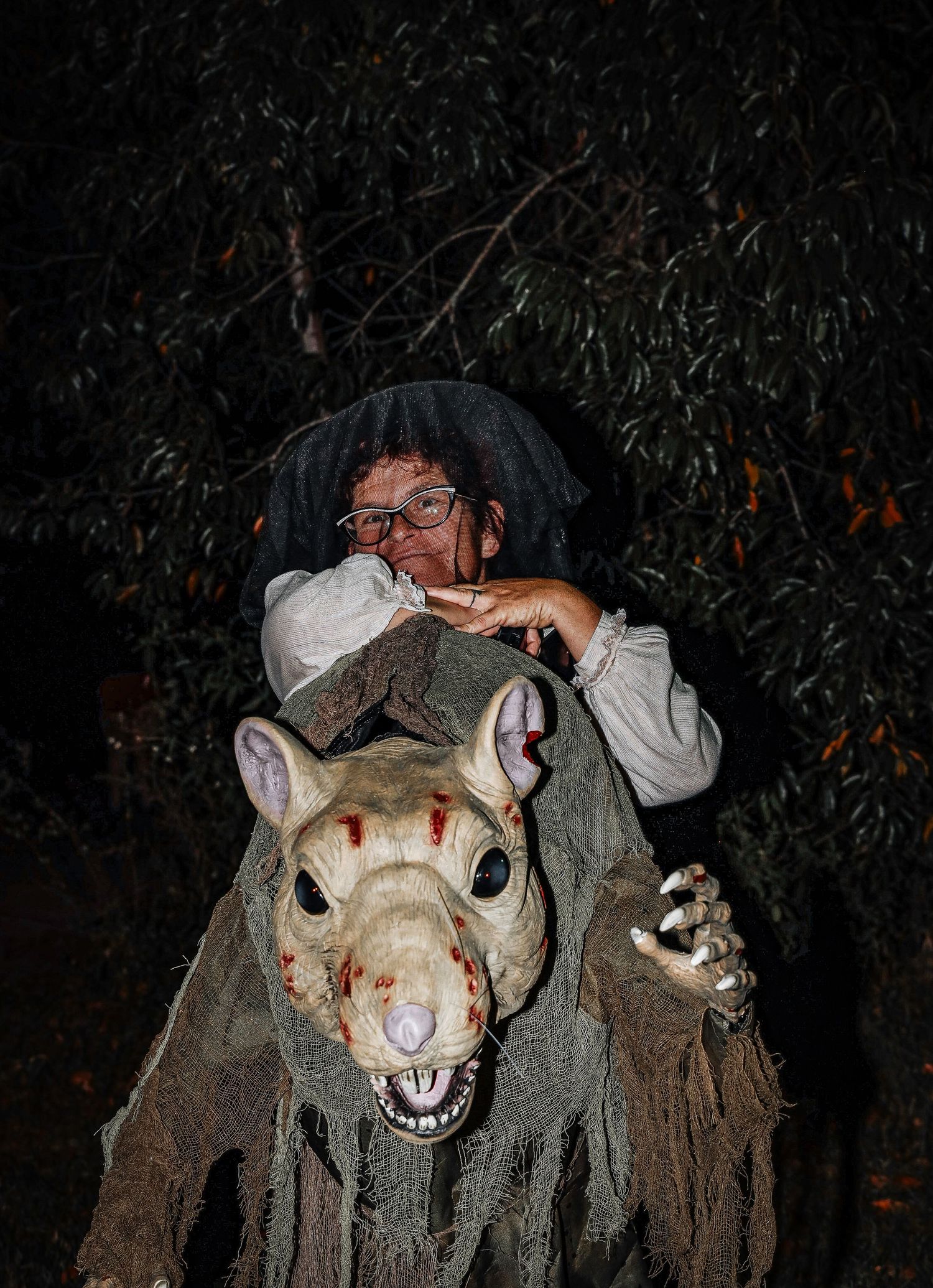 A creepy white rabbit mask with blood stains appears in a dark setting, creating an eerie Halloween atmosphere.