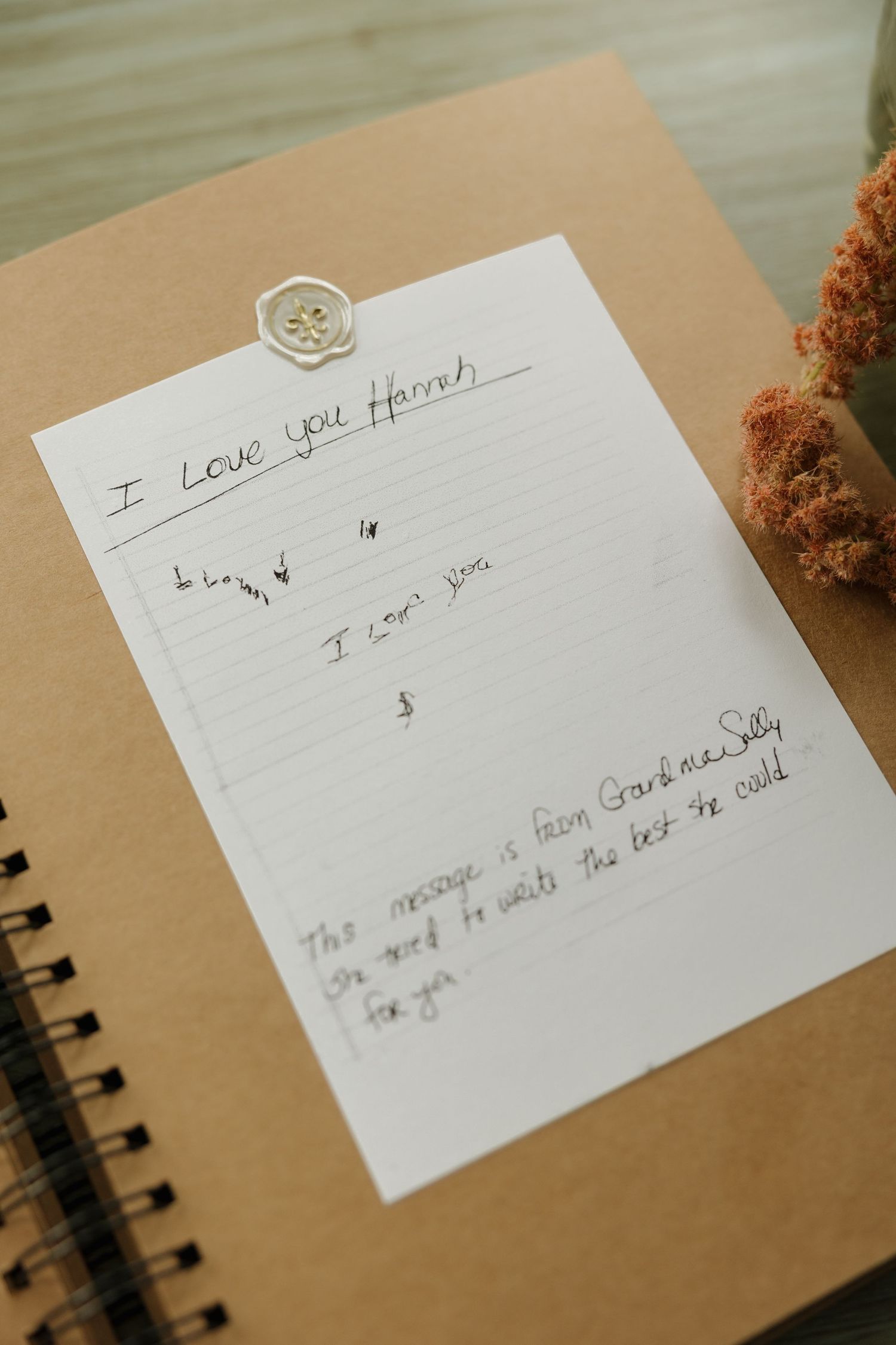 Handwritten love note reading I Love You Hannah on kraft paper journal with wax seal.