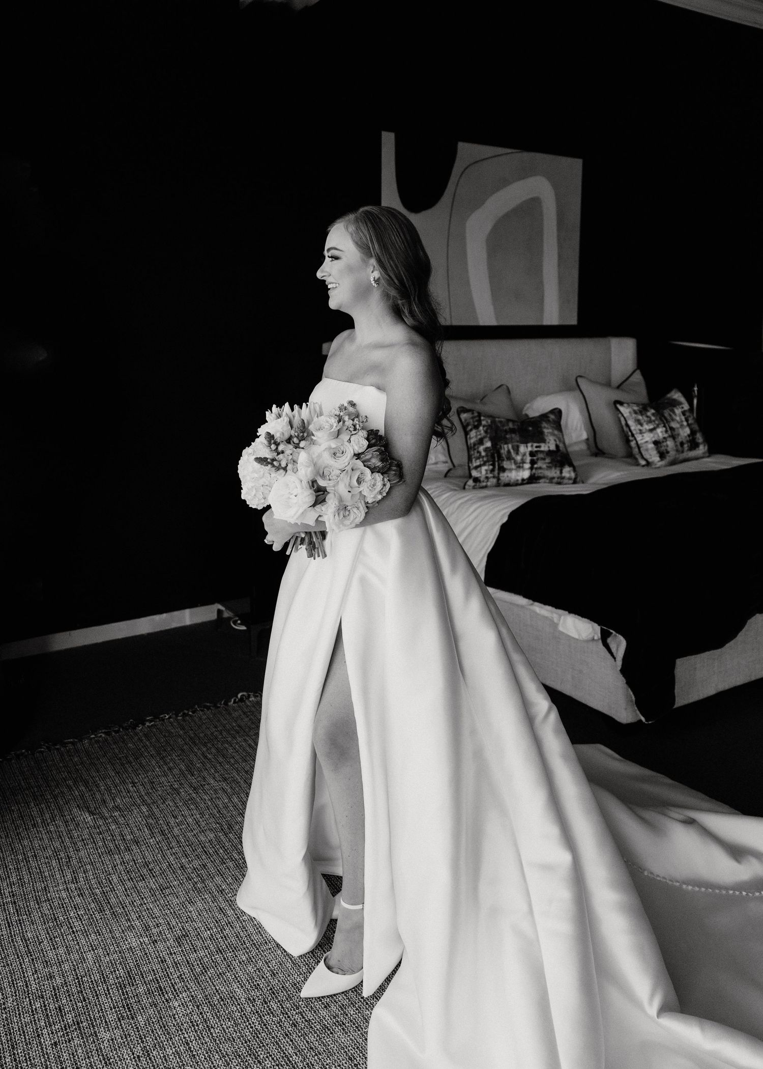 An elegant strapless wedding gown with a full skirt photographed in black and white.