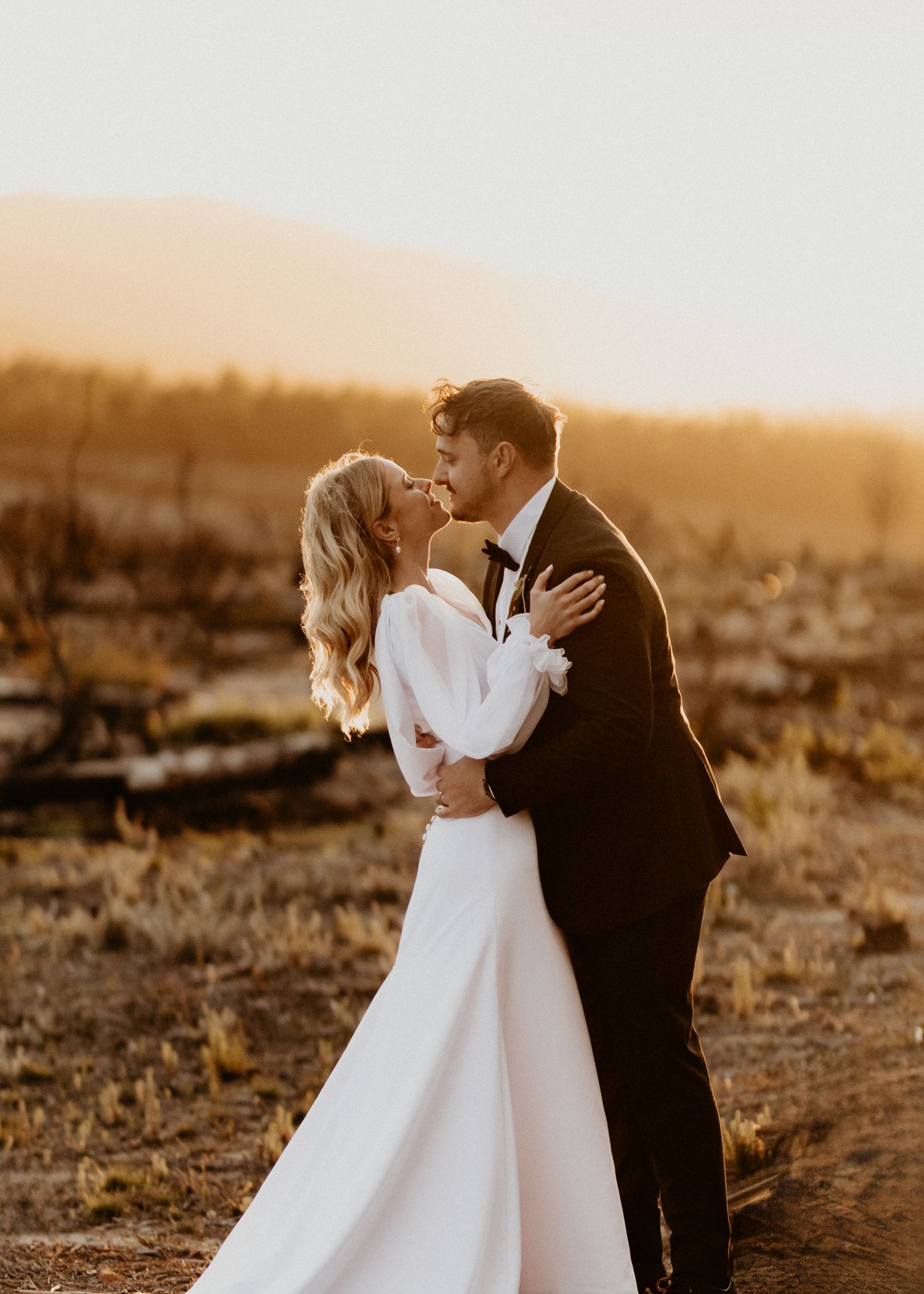 Warm-toned wedding portraits showing loving moments between newlyweds at sunset.