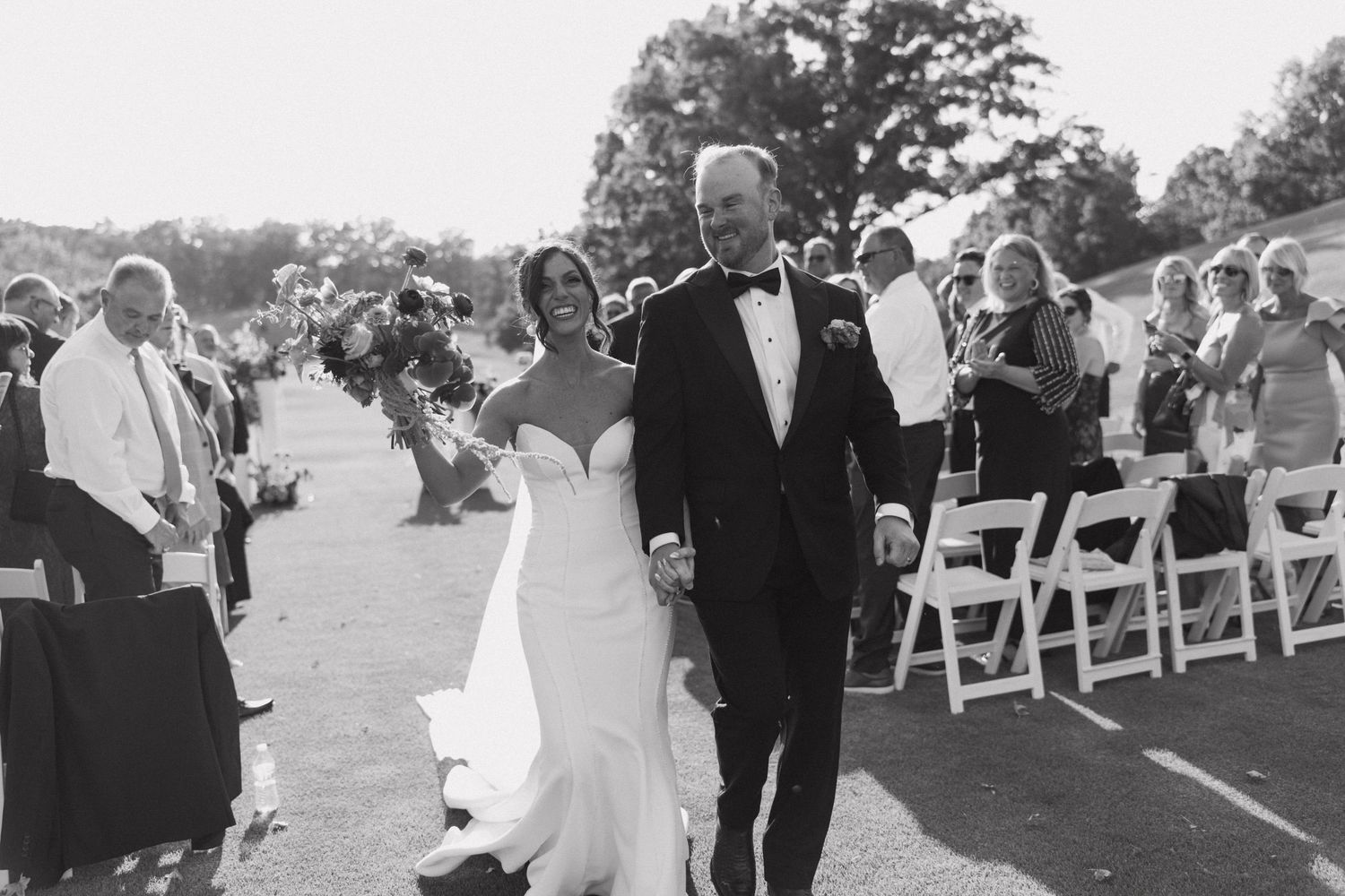 A collection of black and white wedding ceremony photos showing processional moments and outdoor seating arrangements.