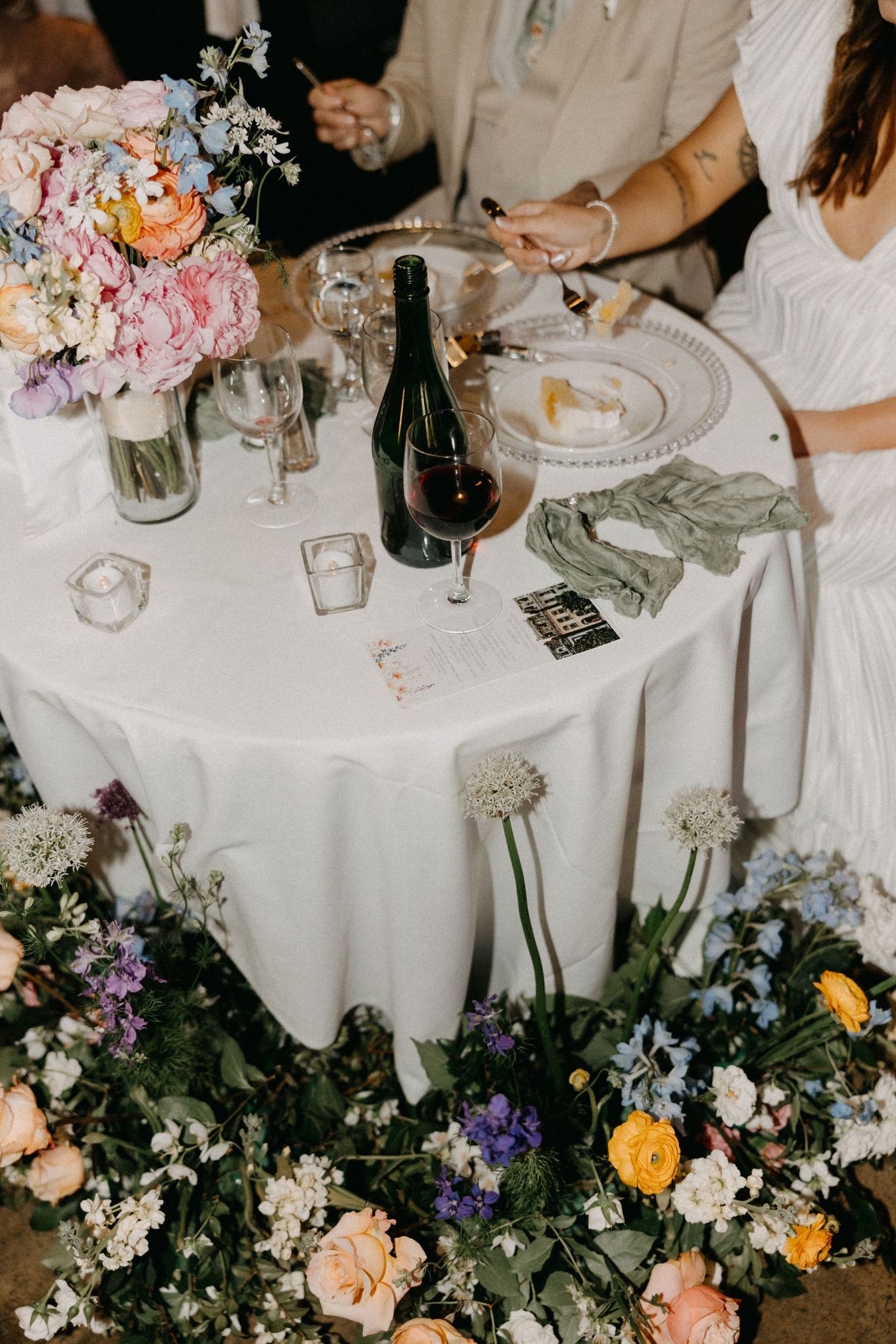Elegant wedding reception tables decorated with colorful floral arrangements and white linens.