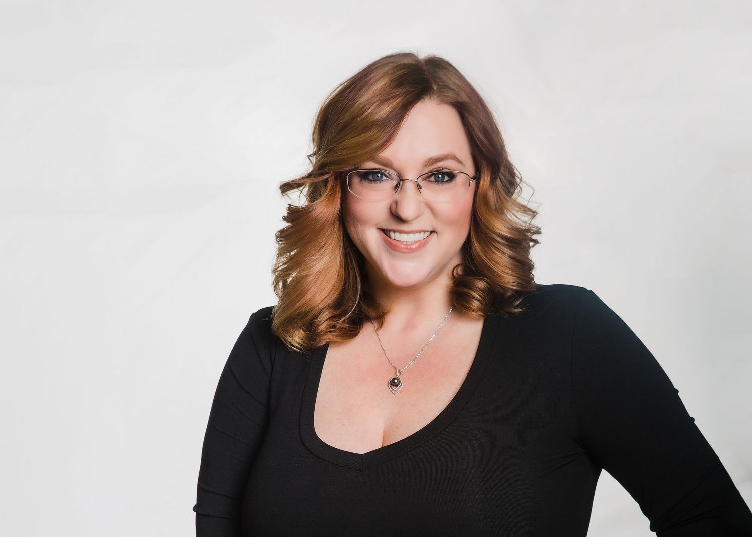 Professional headshot photos of someone in a black top and glasses against a light background.