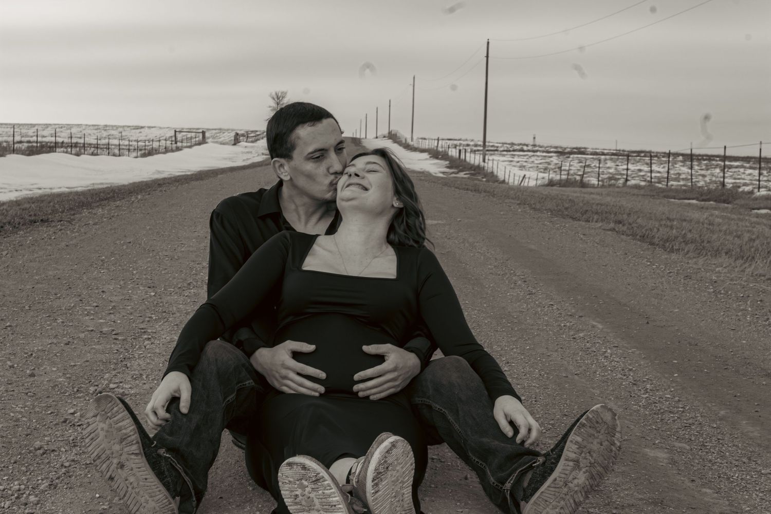 A series of black and white photographs showing intimate romantic moments between two people at a beach setting.