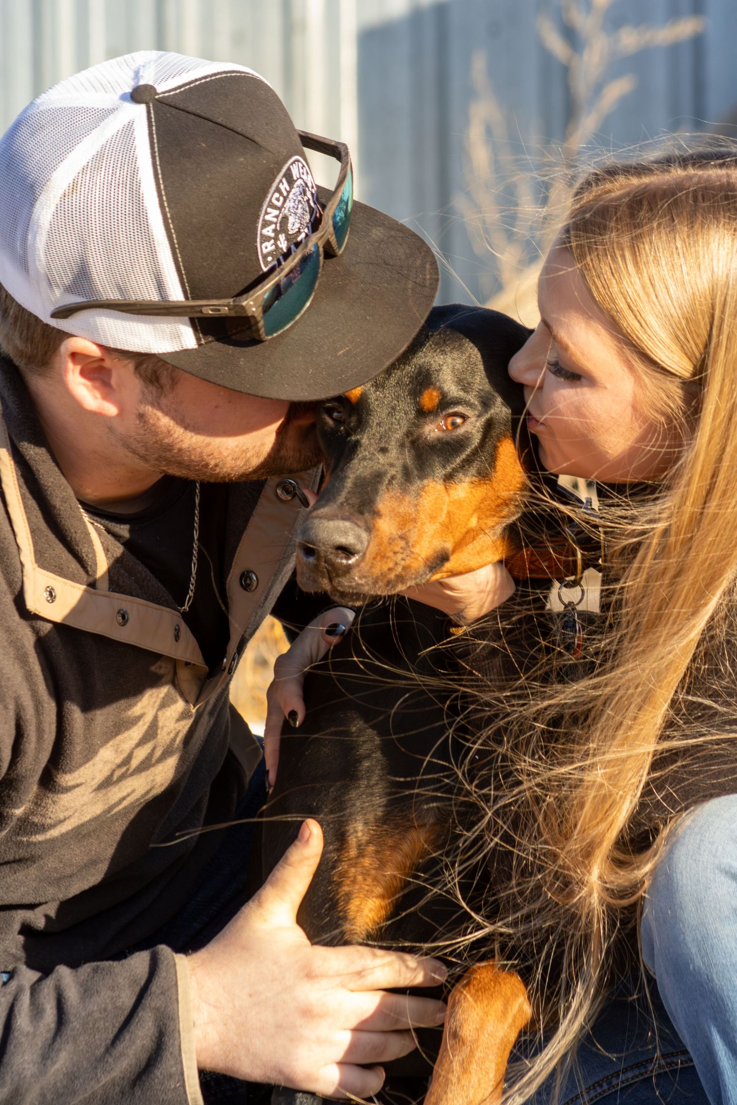 A series of four connected photos showing a person in a baseball cap sharing tender moments with a brown dog.