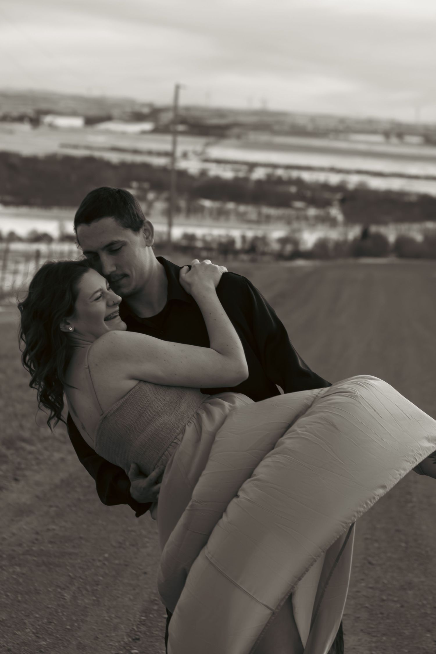 A romantic black and white photo series showing a couple dancing and dipping on a beach at sunset.