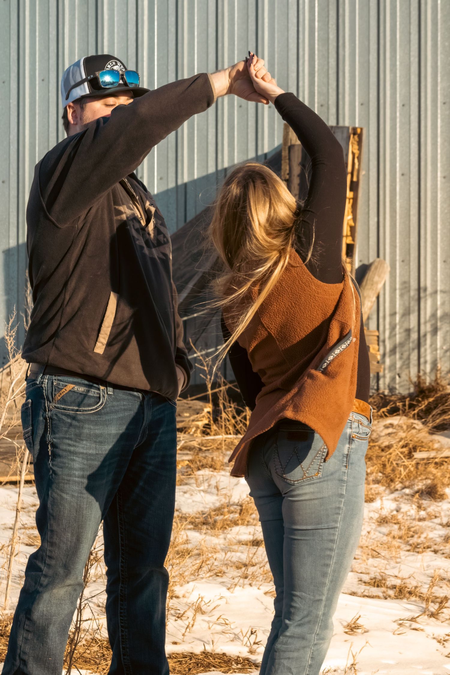 A sequence of people in jeans and black jackets dabbing in front of a metal wall.