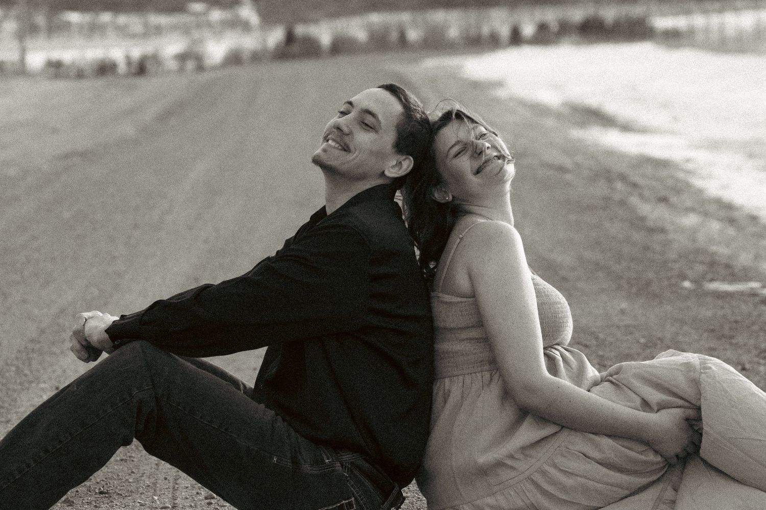 A couple lies together on the ground in a romantic black and white photo series.