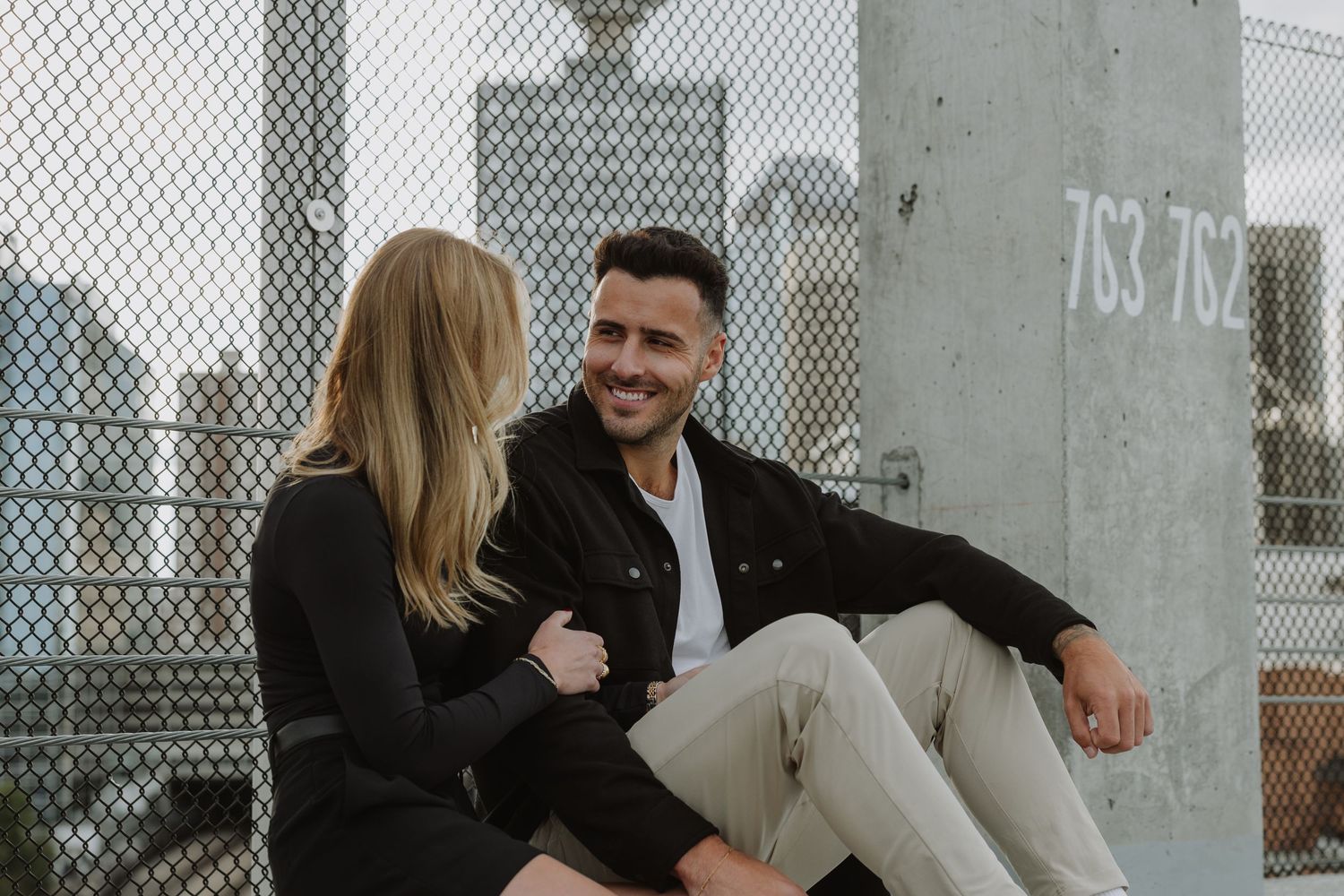 Calgary engagement photographer capturing a couple in downtown’s urban scenery with relaxed, authentic storytelling style