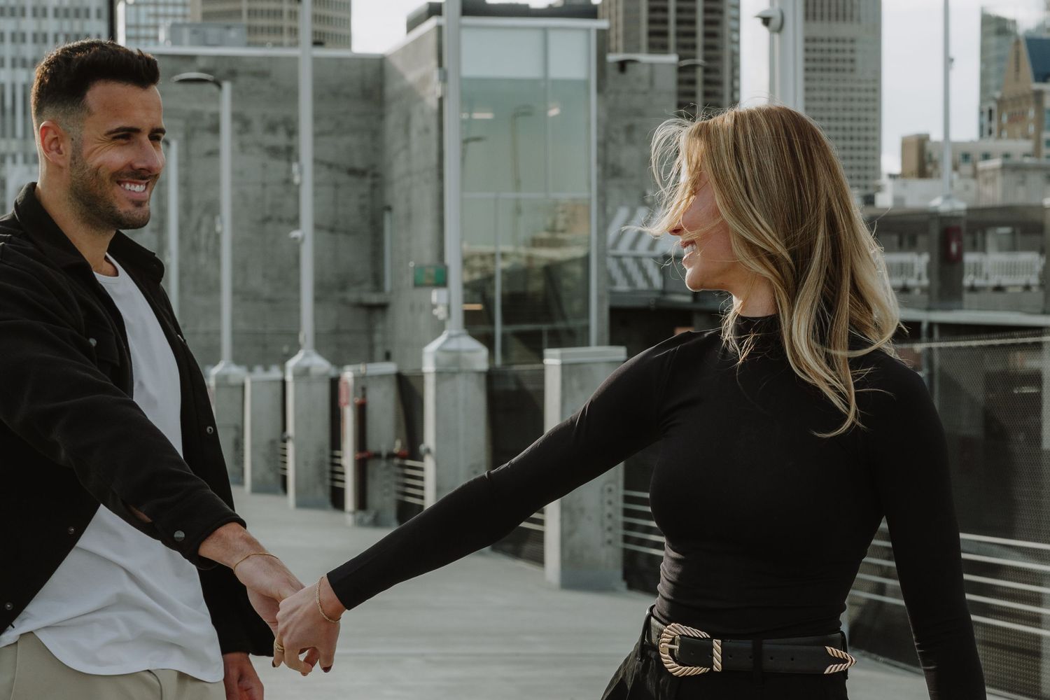 Calgary engagement photographer capturing a couple in downtown’s urban scenery with relaxed, authentic storytelling style